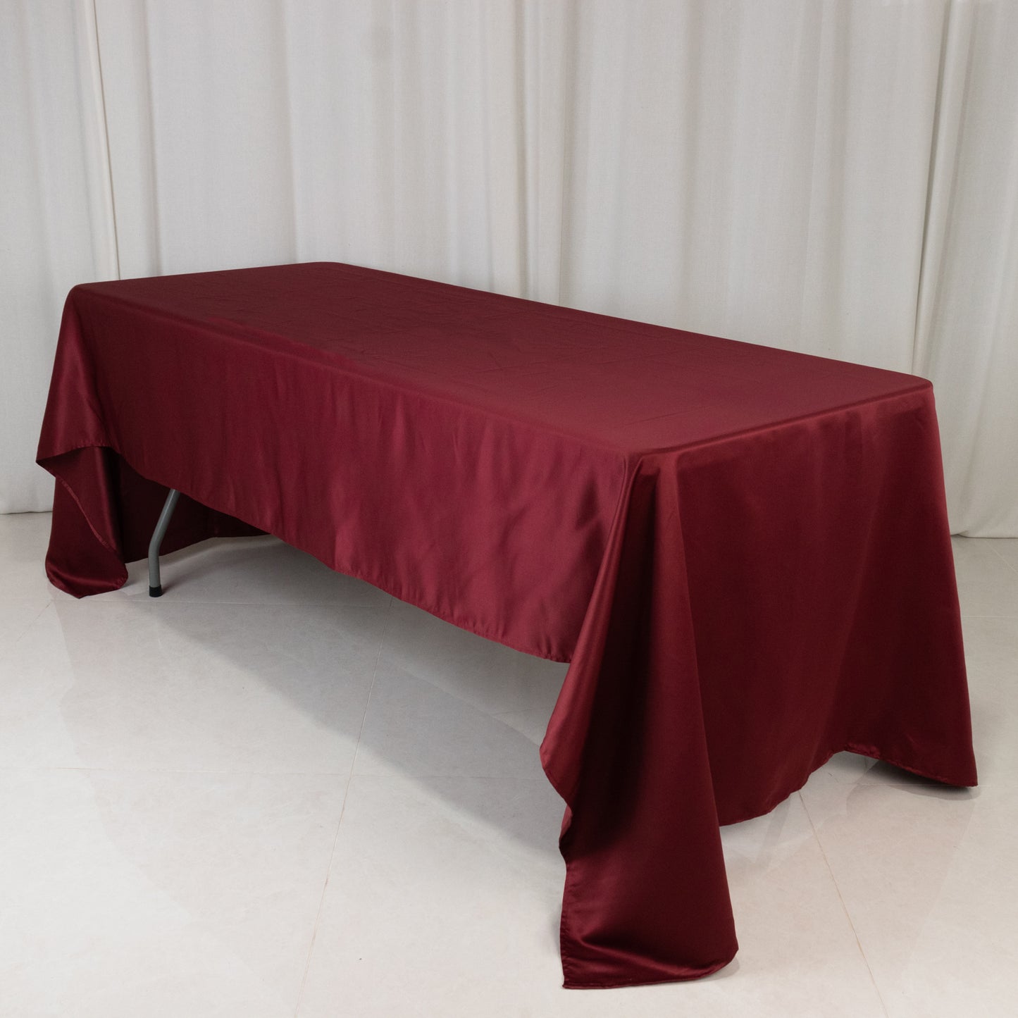 Burgundy satin rectangle tablecloth on a table.