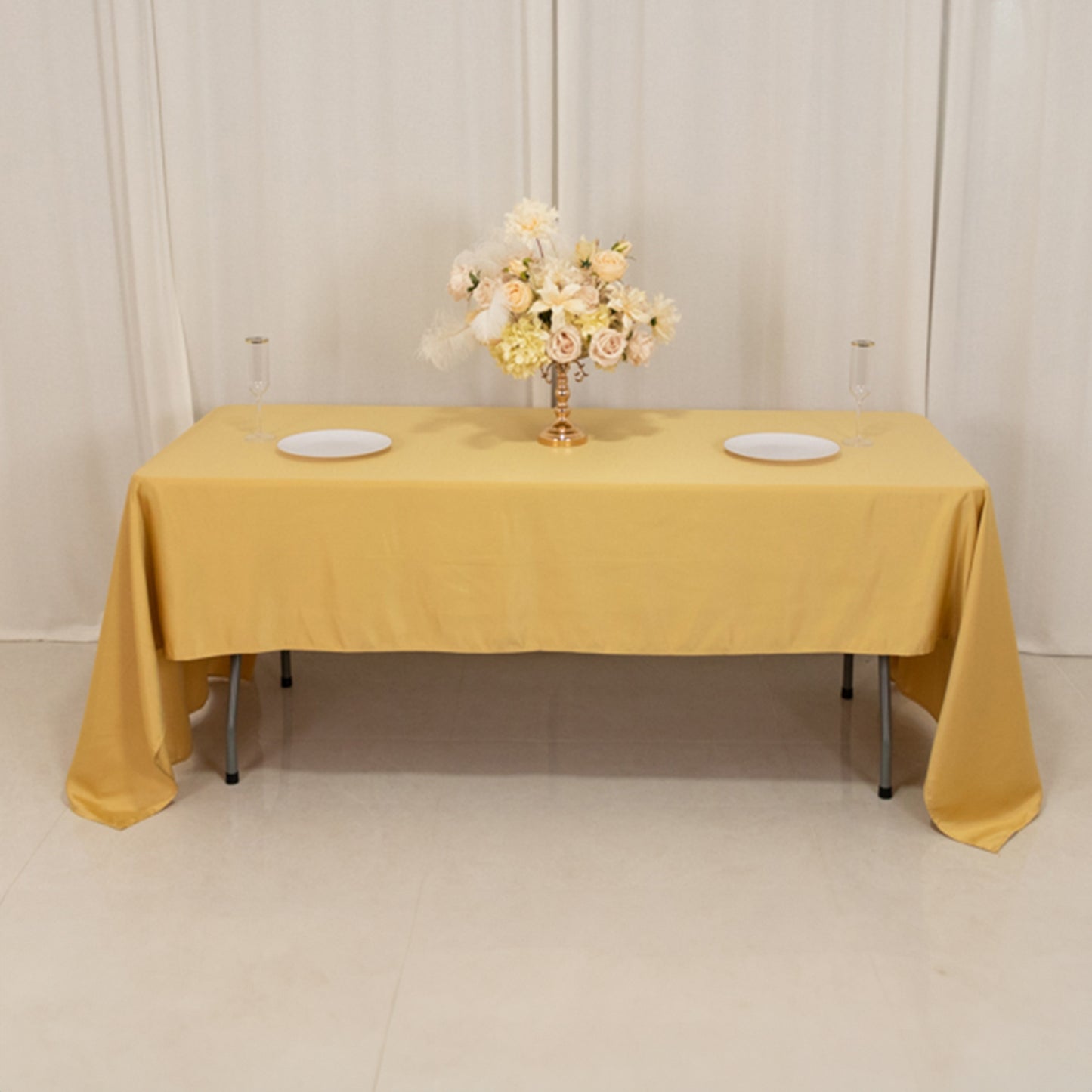Champagne satin tablecloth draped elegantly on a table with floral centerpiece.