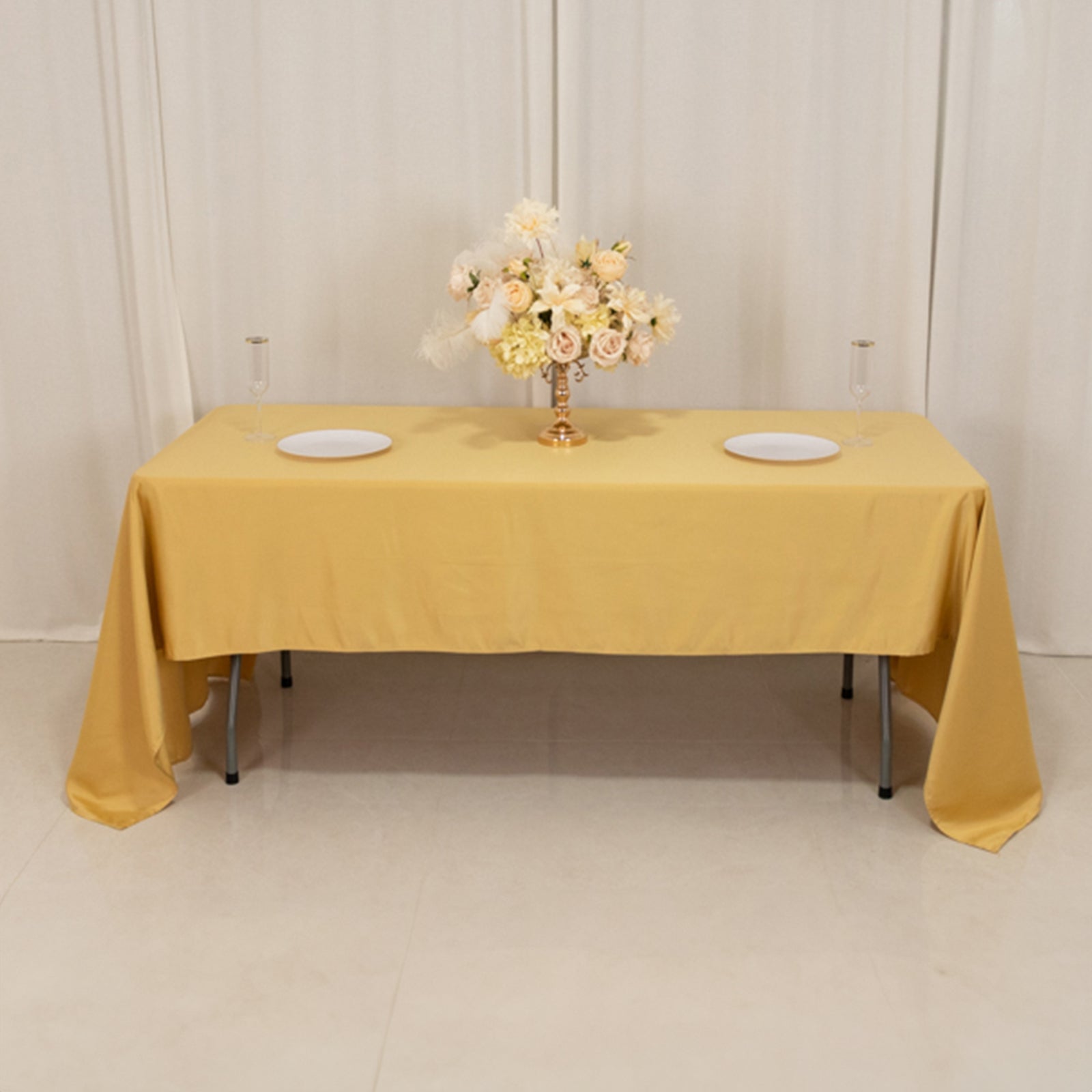 Champagne satin tablecloth draped elegantly on a table with floral centerpiece.