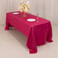 Fuchsia satin rectangular tablecloth on a dining table with floral centerpiece.