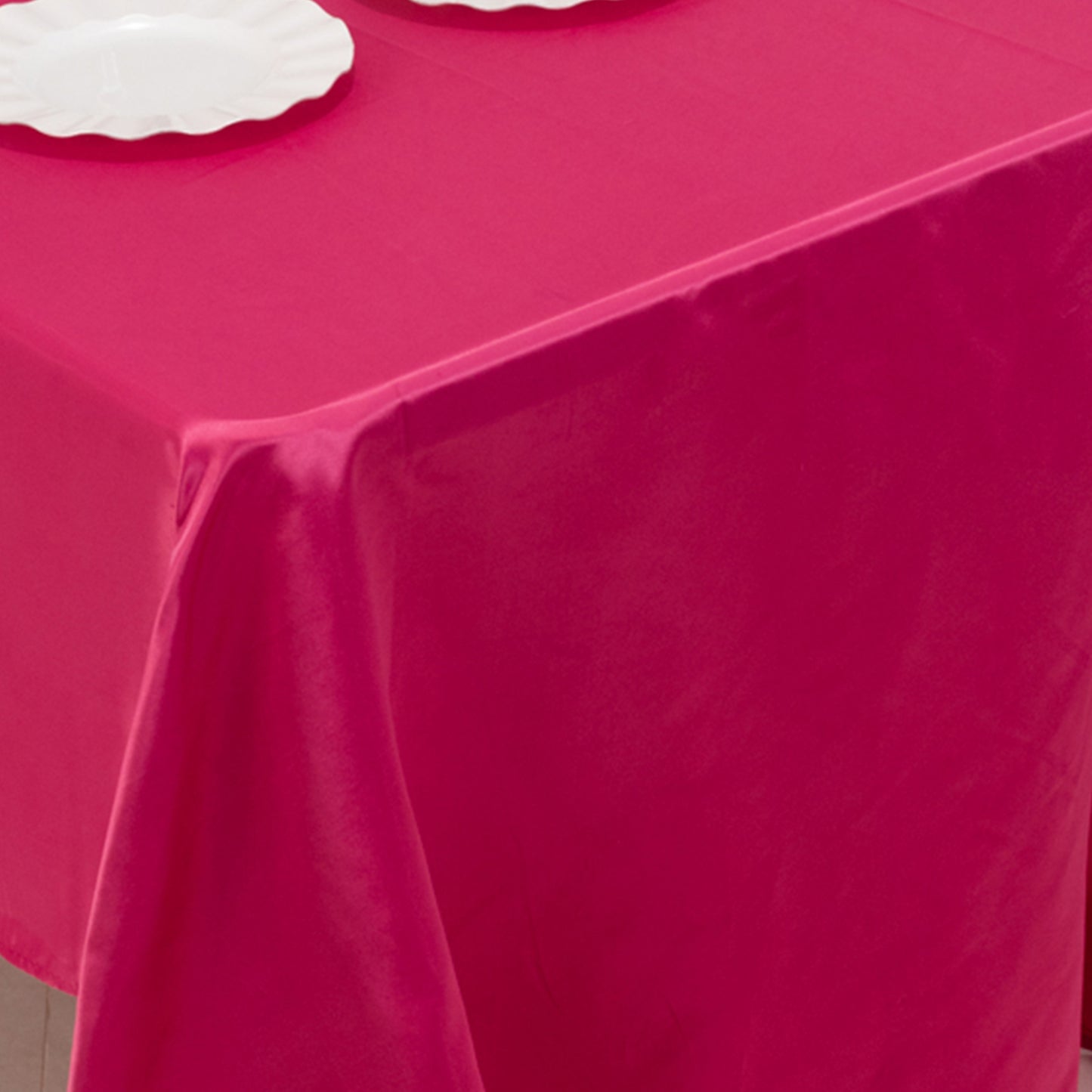 Fuchsia satin rectangle tablecloth on a dining table.
