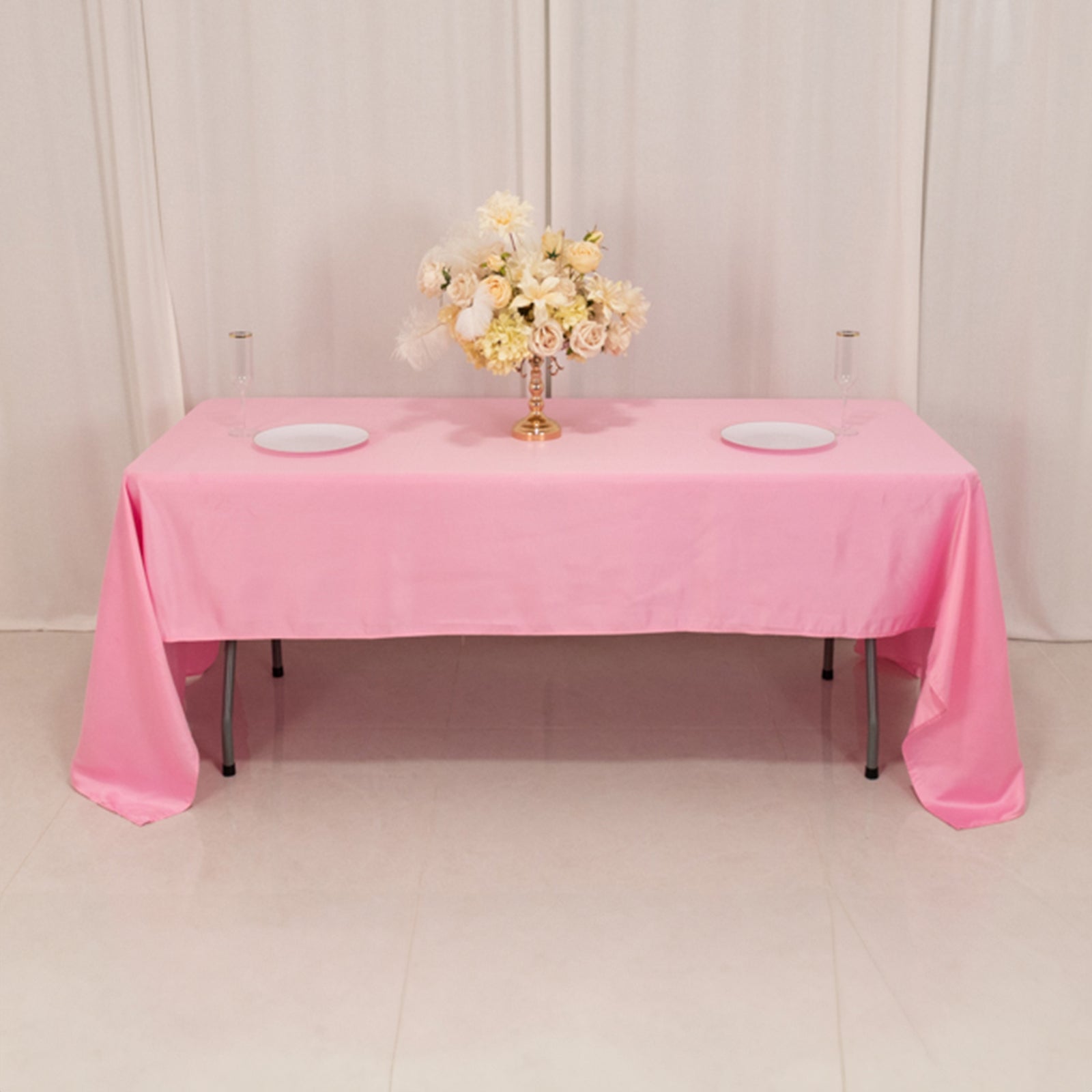 Pink Lamour satin rectangle tablecloth on a table with floral arrangement.