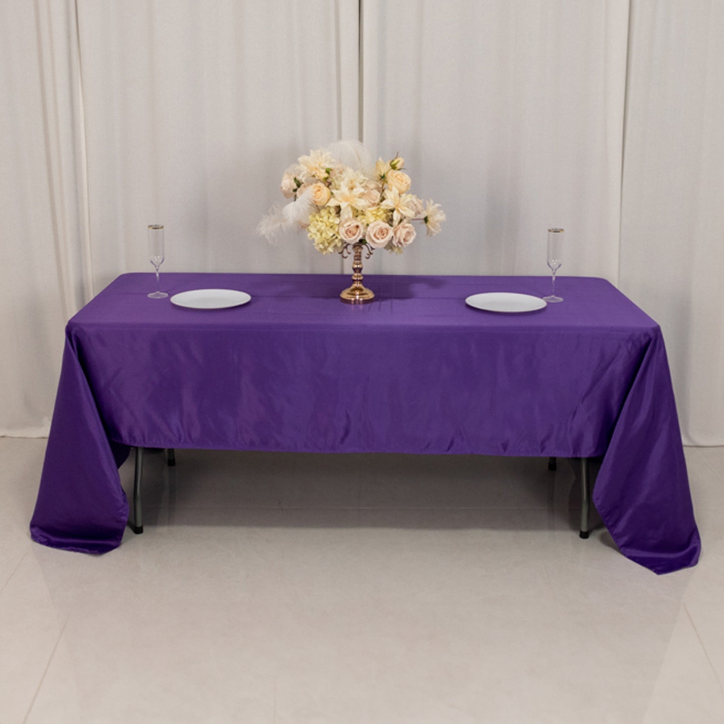 Purple Lamour satin tablecloth on a dining table with floral centerpiece.