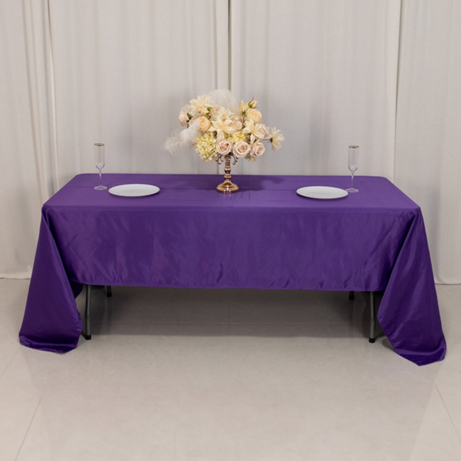 Purple Lamour satin tablecloth on a dining table with floral centerpiece.