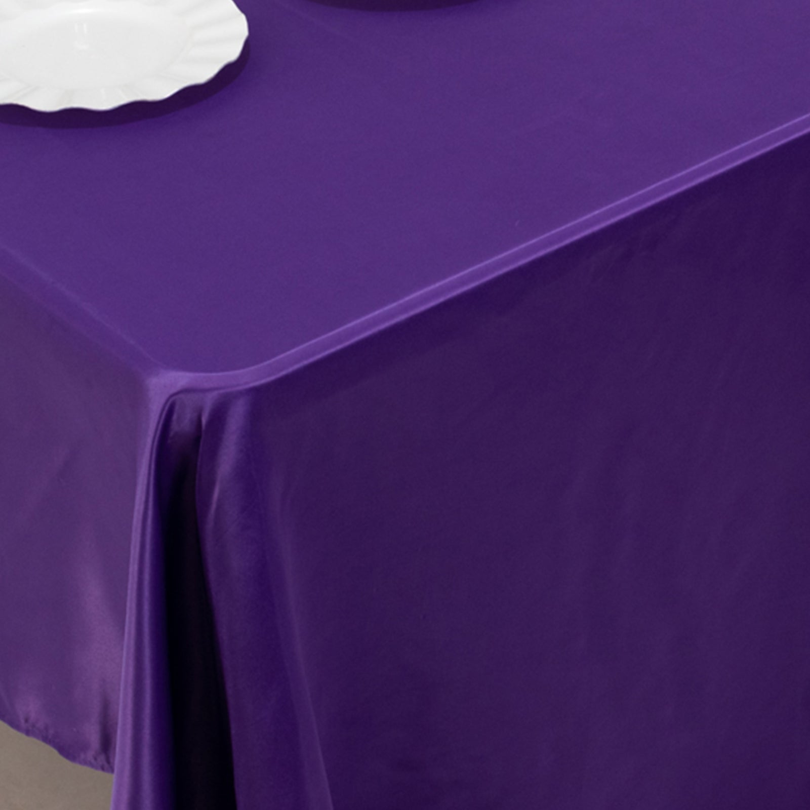 Purple Lamour Satin Rectangle Tablecloth on a table.