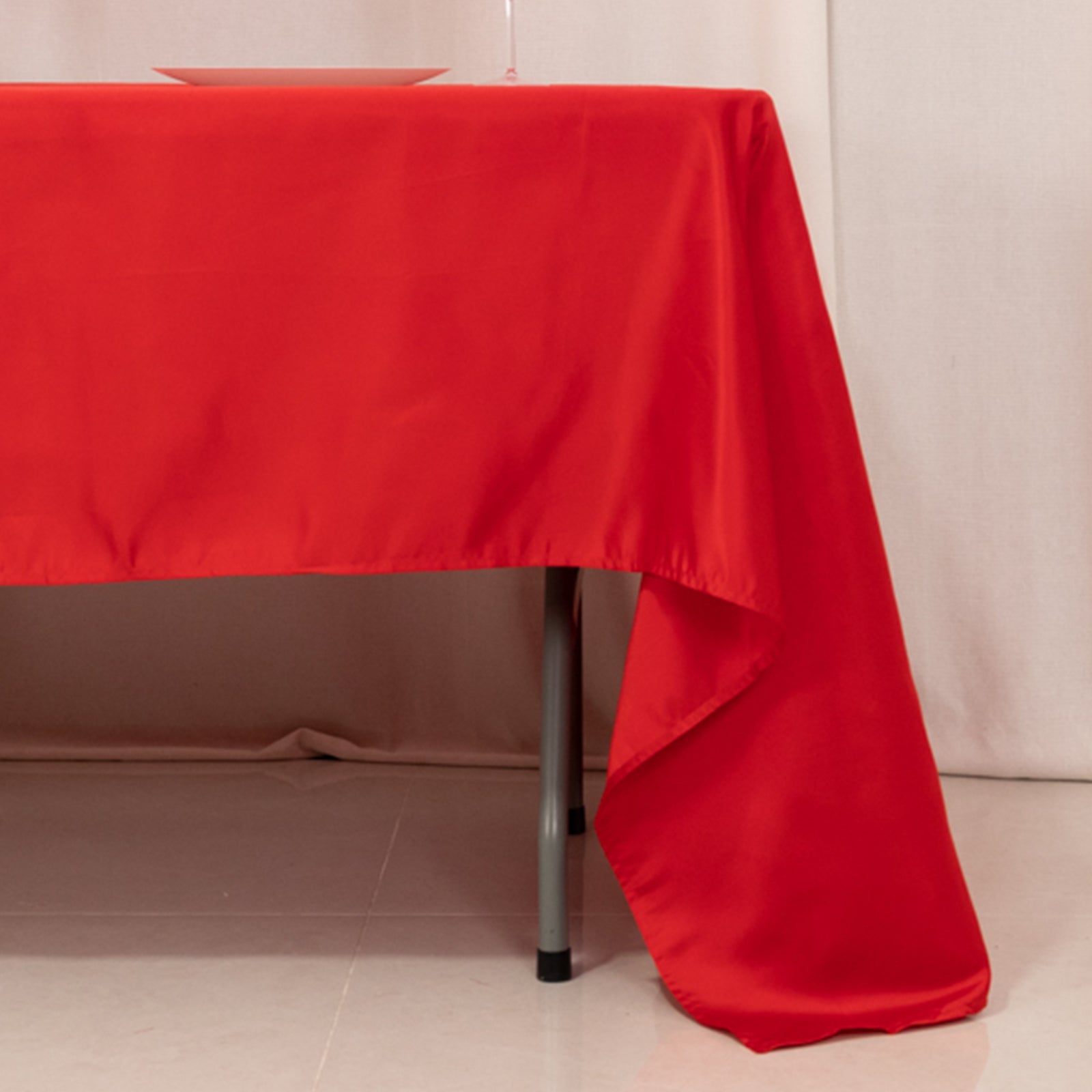 Red Lamour satin tablecloth, 60"x126" rectangle, draping elegantly.