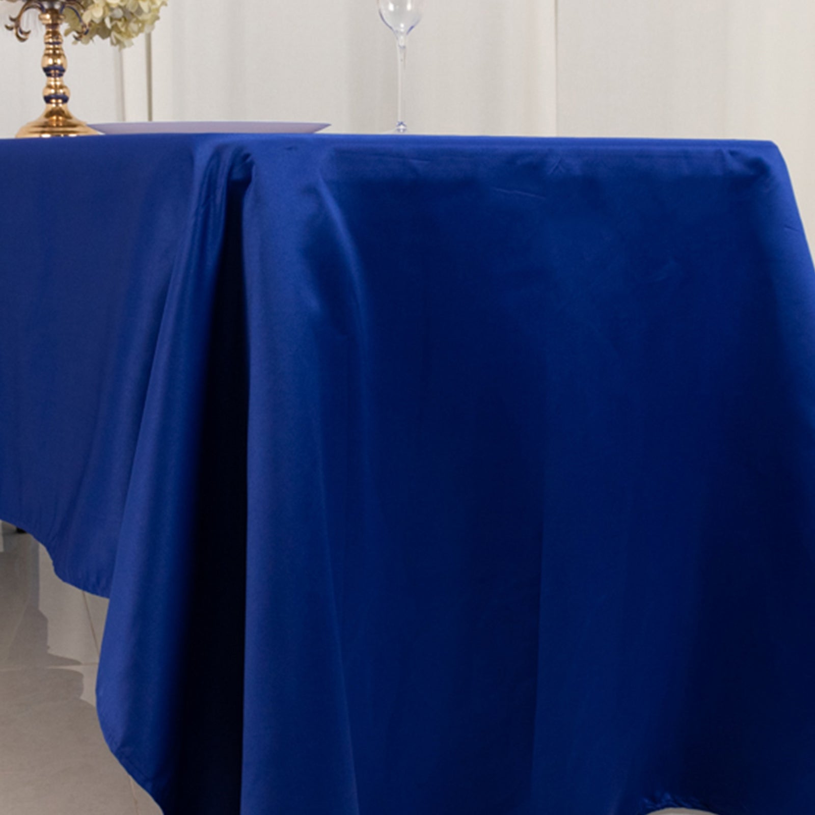 Royal Blue Lamour Satin Rectangle Tablecloth on a table.