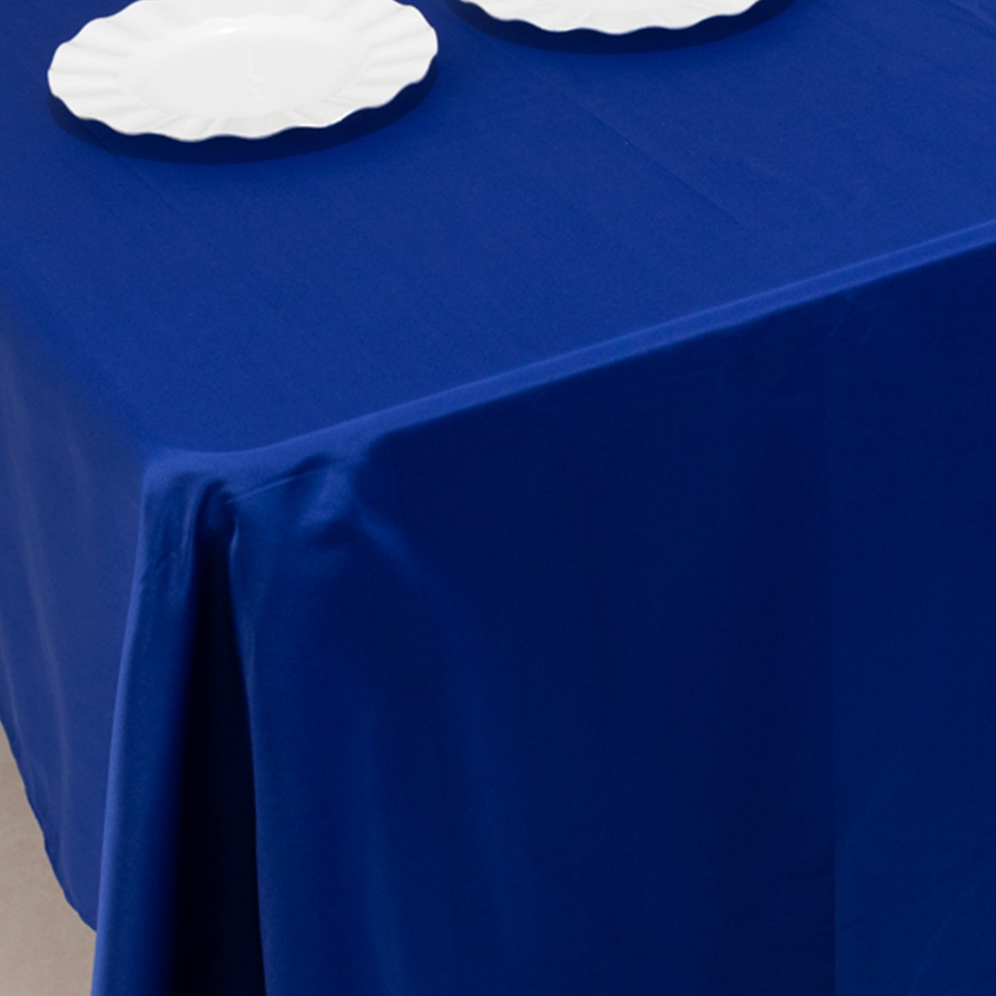 Royal Blue Lamour Satin Rectangle Tablecloth on a table.
