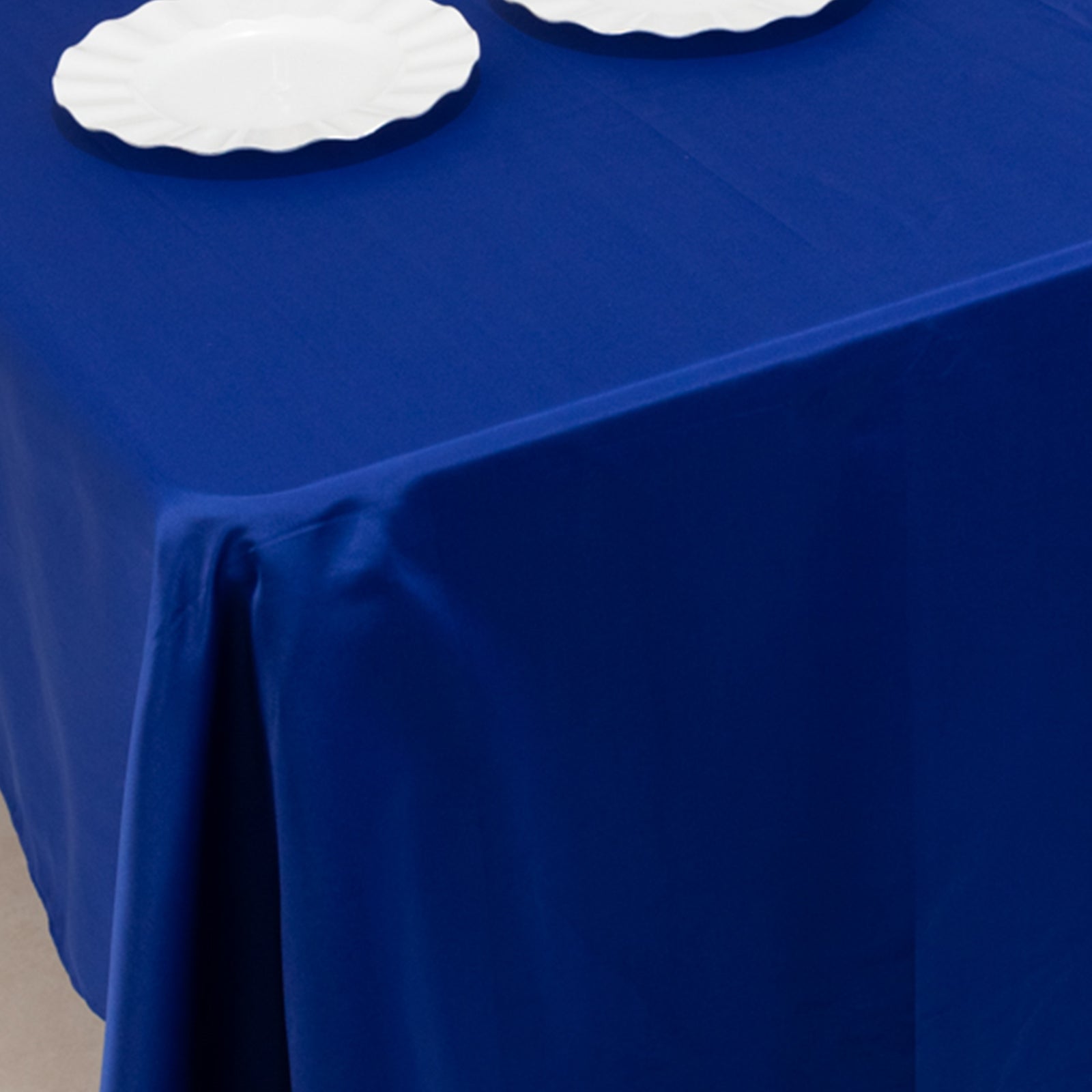 Royal Blue Lamour Satin Rectangle Tablecloth on a table.