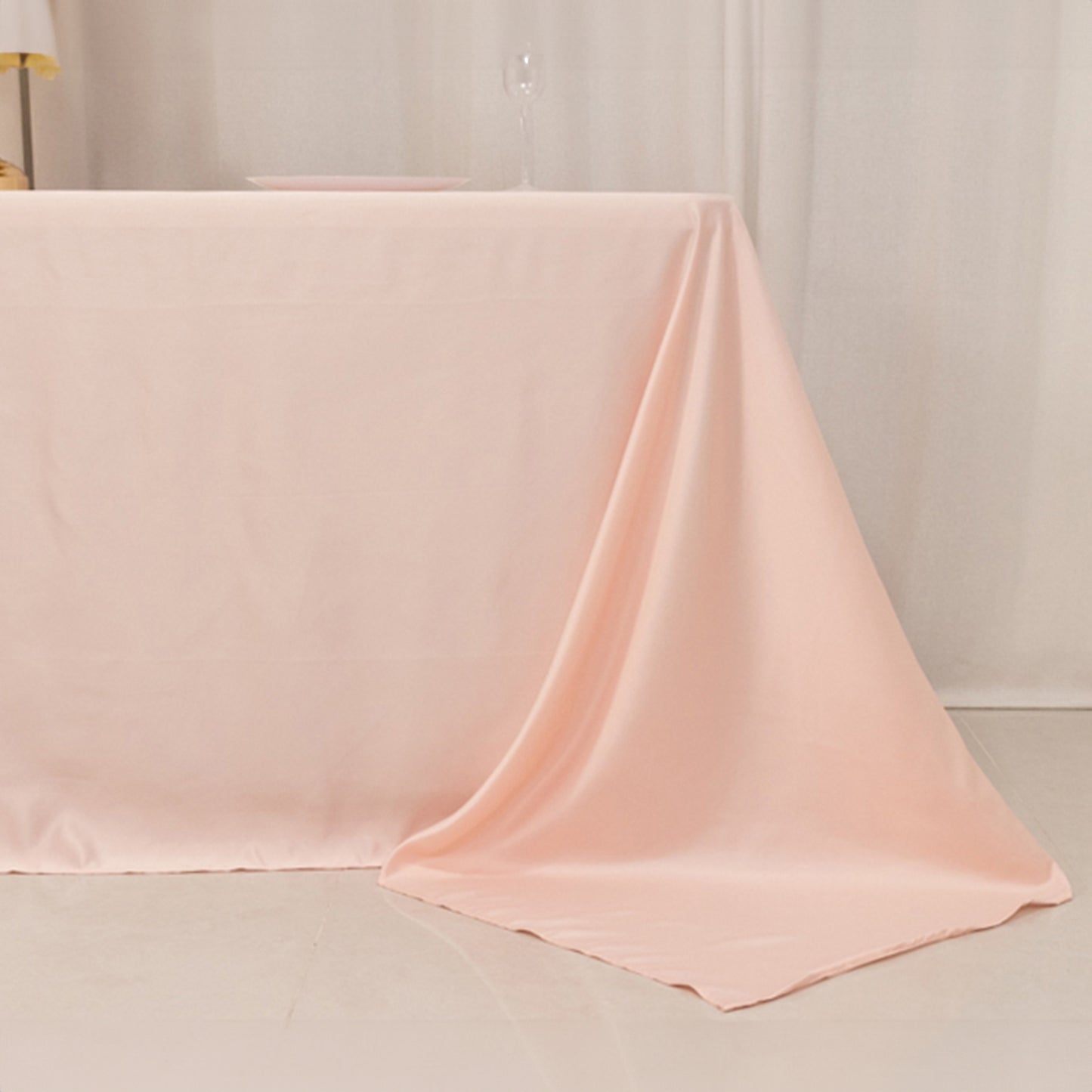 Blush satin tablecloth for 6-foot table with floor-length drop.