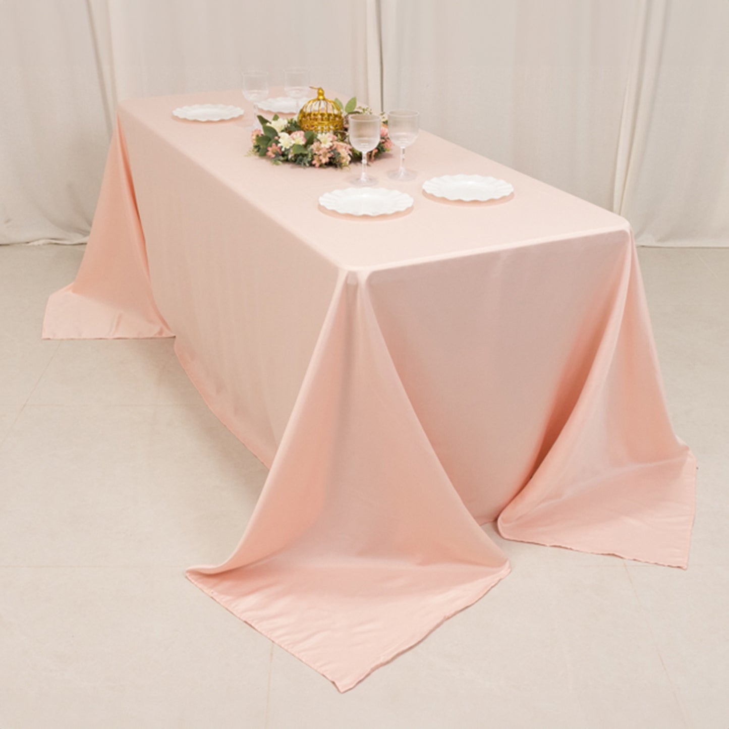 Blush satin tablecloth draped elegantly on a 6-foot table.