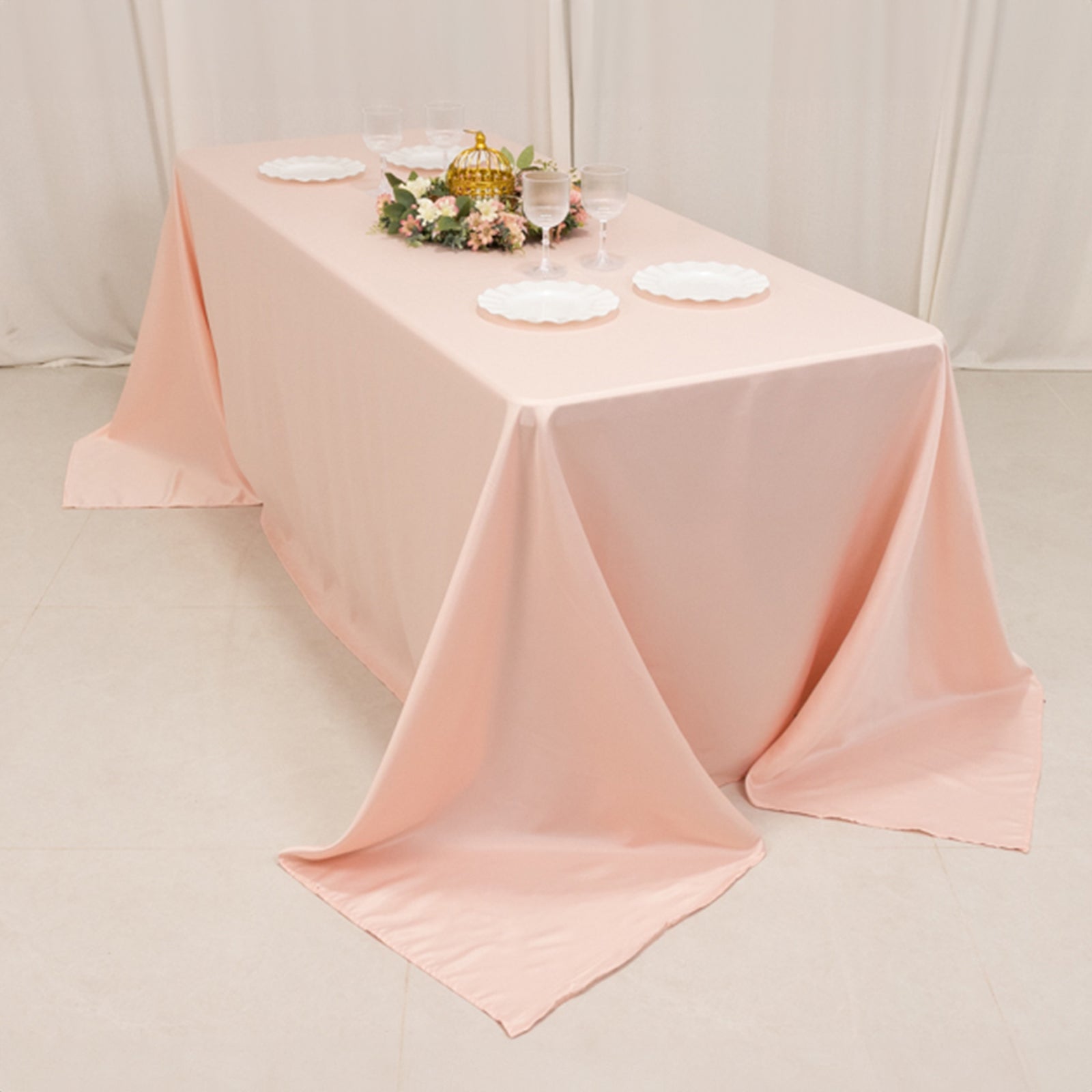 Blush satin tablecloth draped elegantly on a 6-foot table.