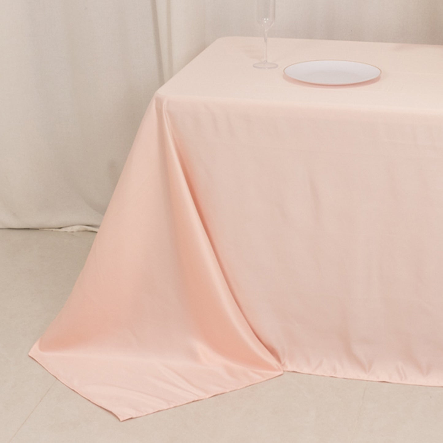 Blush satin tablecloth for 6-foot table with floor-length drop.