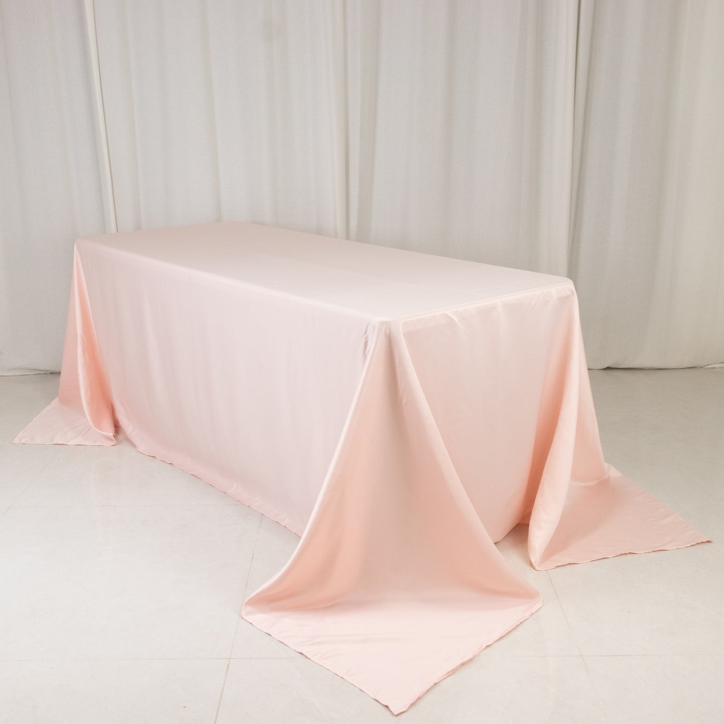 Blush satin tablecloth for a 6-foot table with floor-length drop.