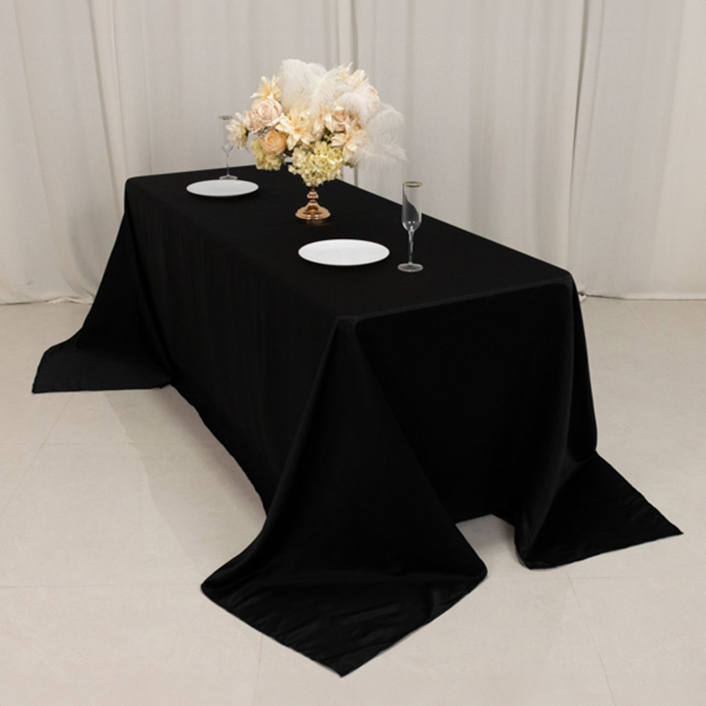 Black seamless lamour satin tablecloth for 6-foot table with floor-length drop.