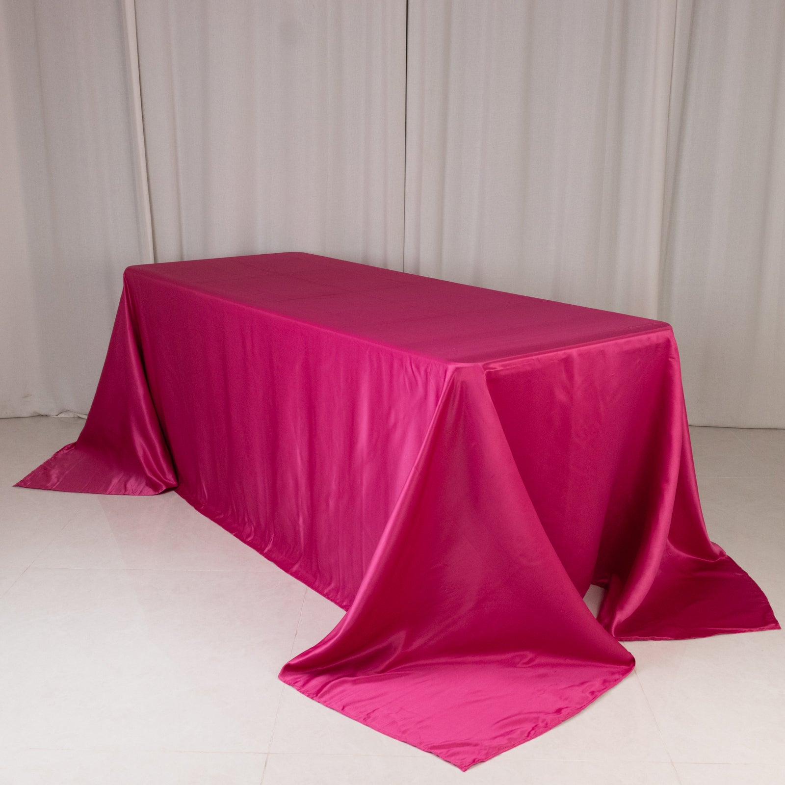 Fuchsia satin tablecloth for 6-foot table with floor-length drop.