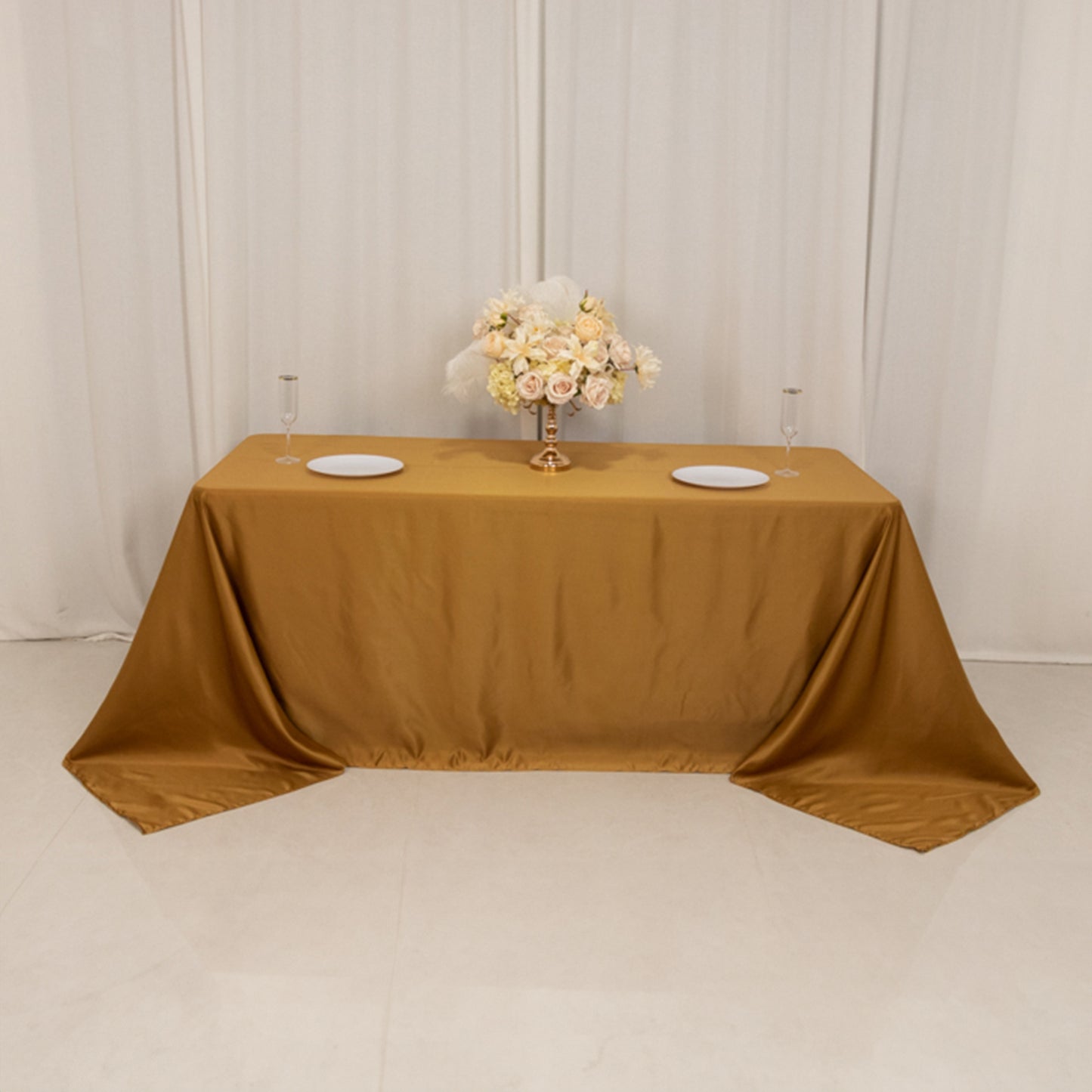 Gold satin tablecloth draped elegantly on a 6-foot table.