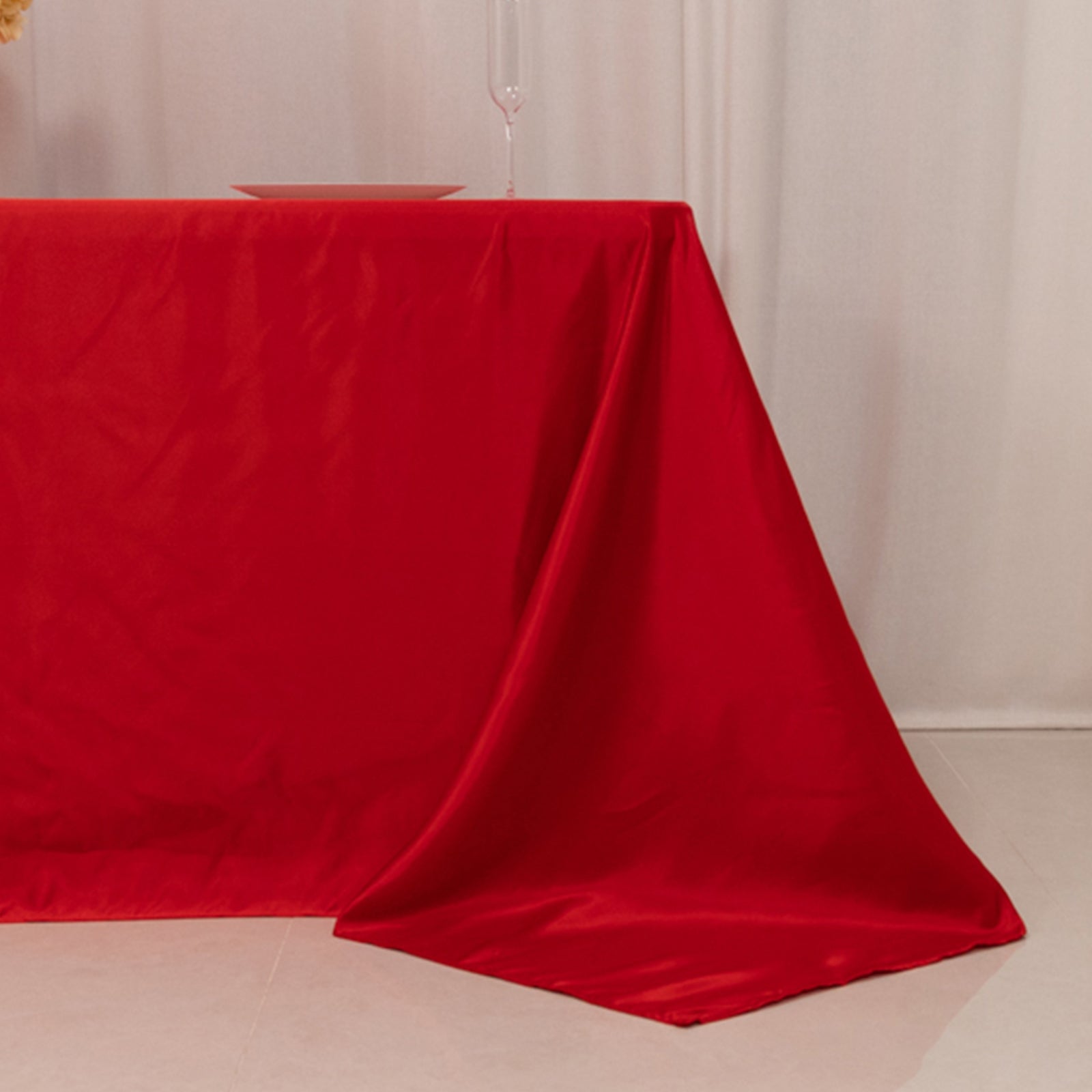 Red seamless satin tablecloth for 6-foot table with floor-length drop.