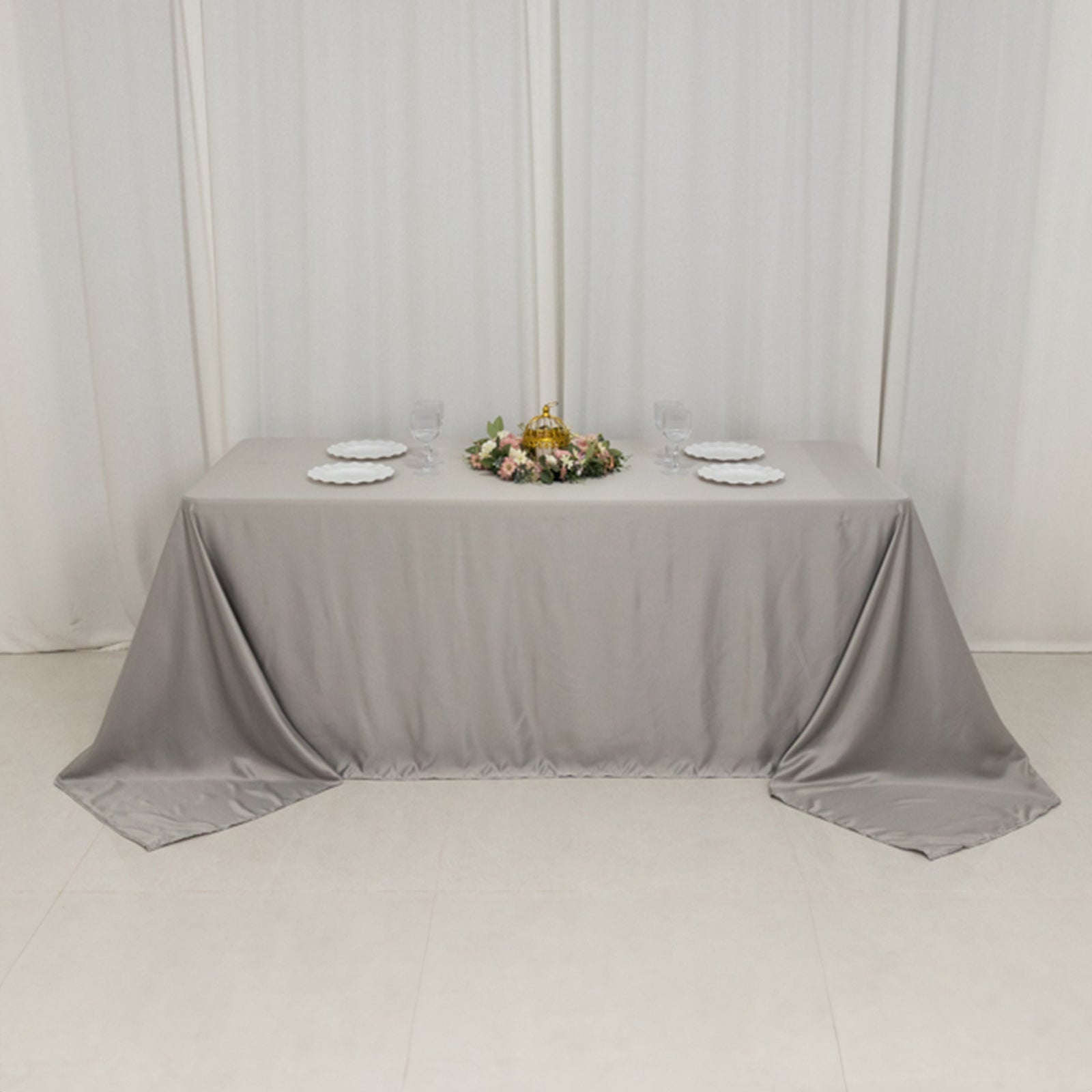 Silver satin tablecloth draping elegantly over a 6-foot table.