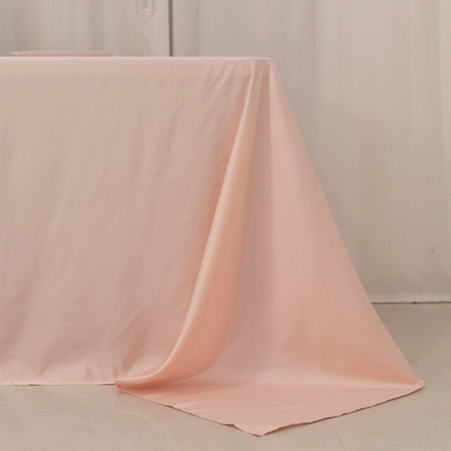 Blush satin tablecloth for 8-foot table with floor-length drop.