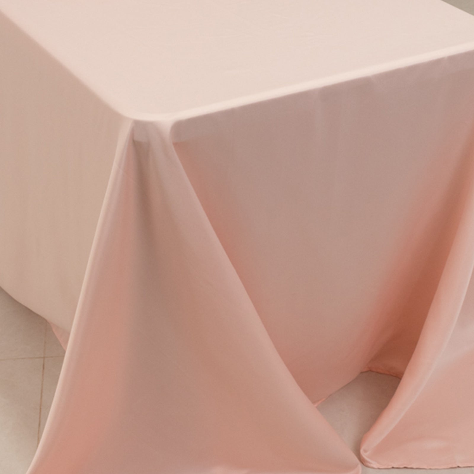 Blush satin tablecloth for 8-foot table with floor-length drop.