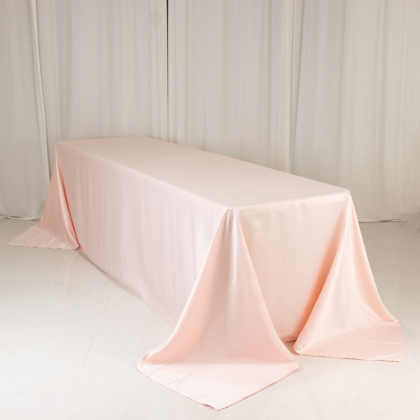 Blush satin tablecloth for 8-foot table with floor-length drop.
