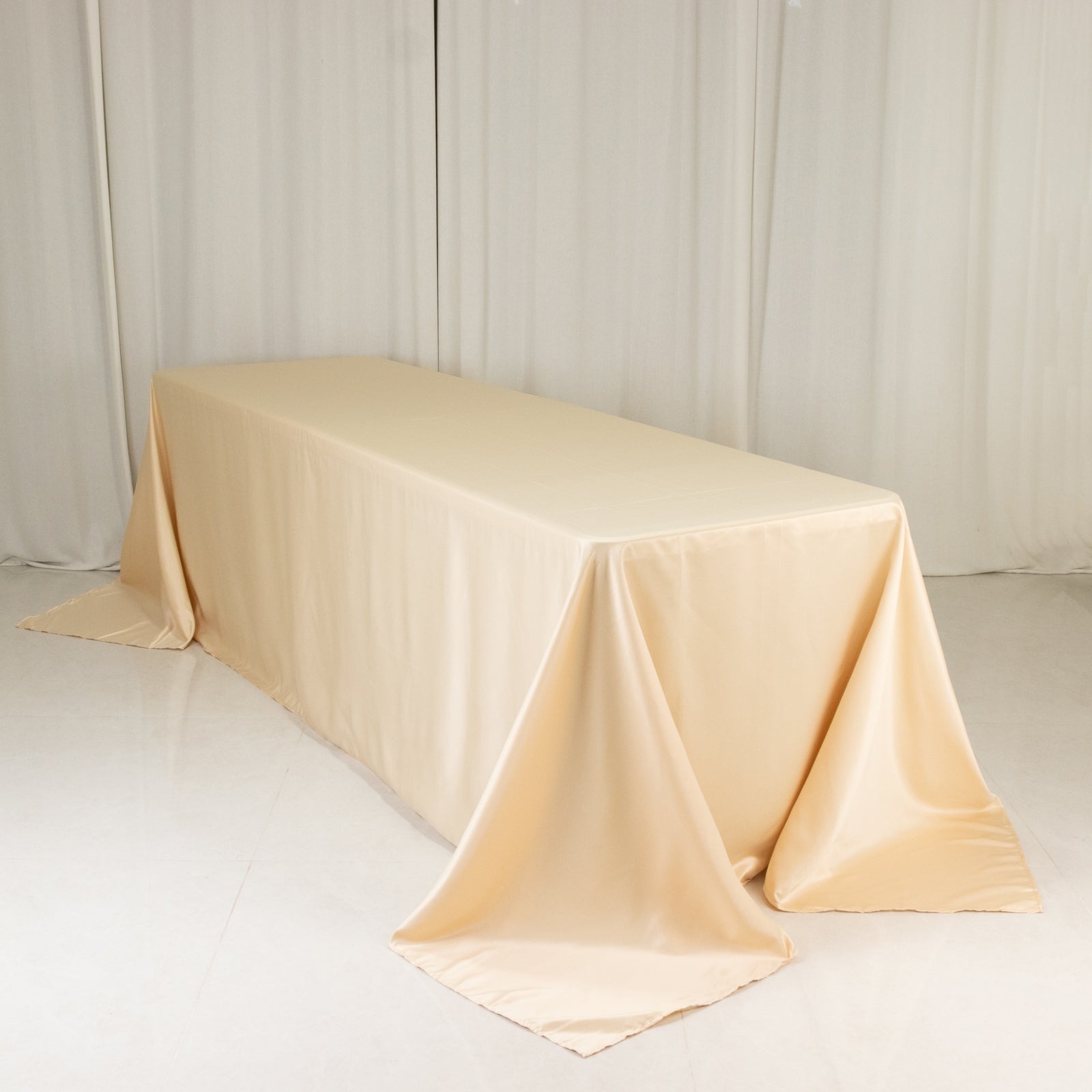 Beige seamless satin tablecloth for 8-foot table with floor-length drop.