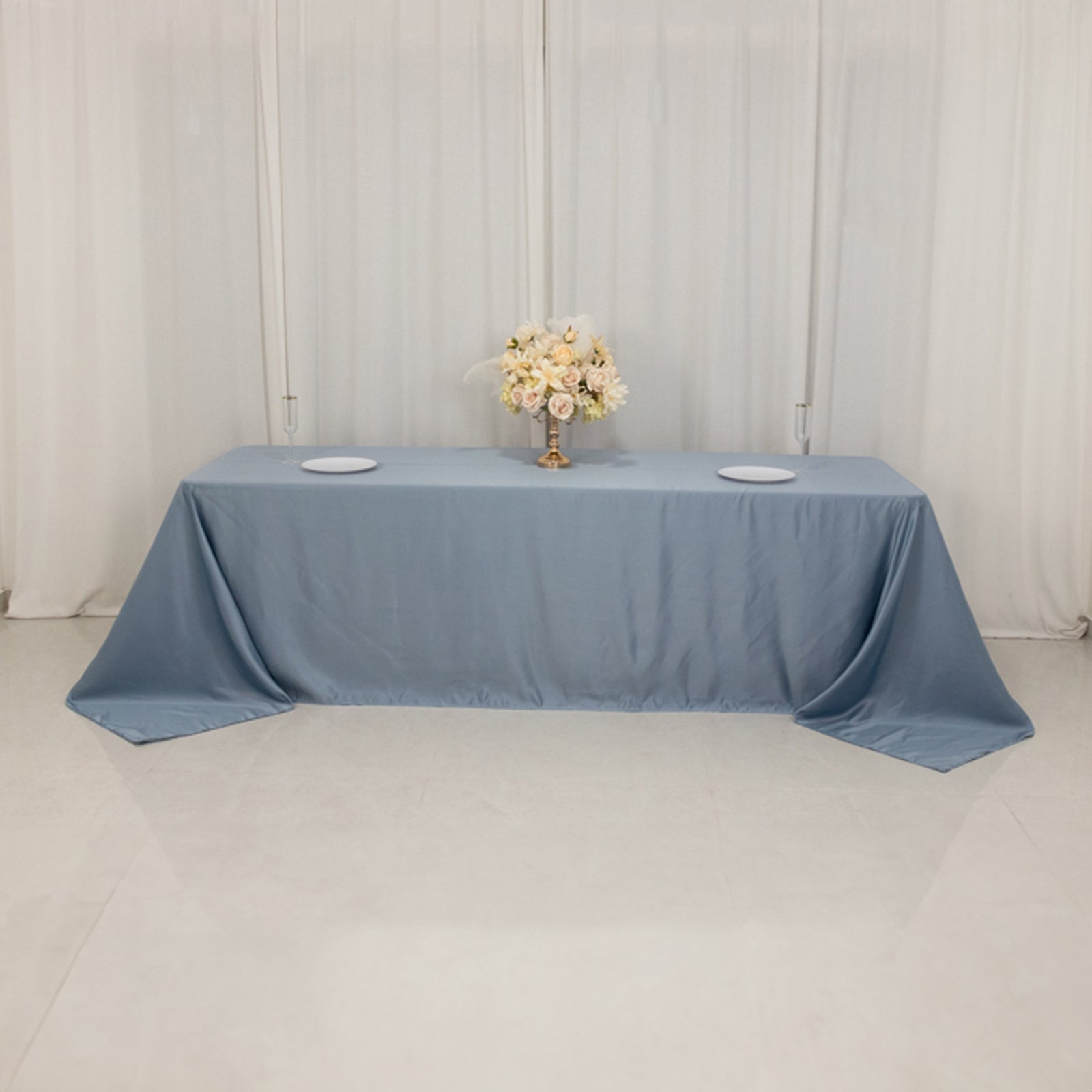Dusty blue satin tablecloth draping elegantly over an 8-foot table.