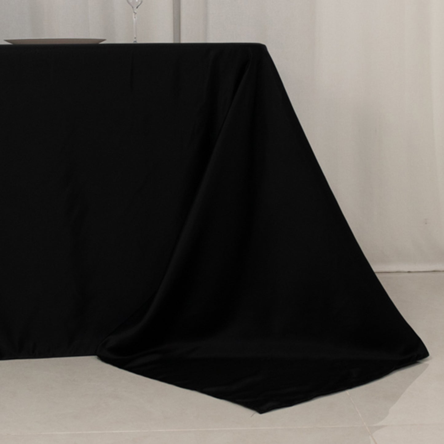 Black seamless satin tablecloth for an 8-foot table with floor-length drop.