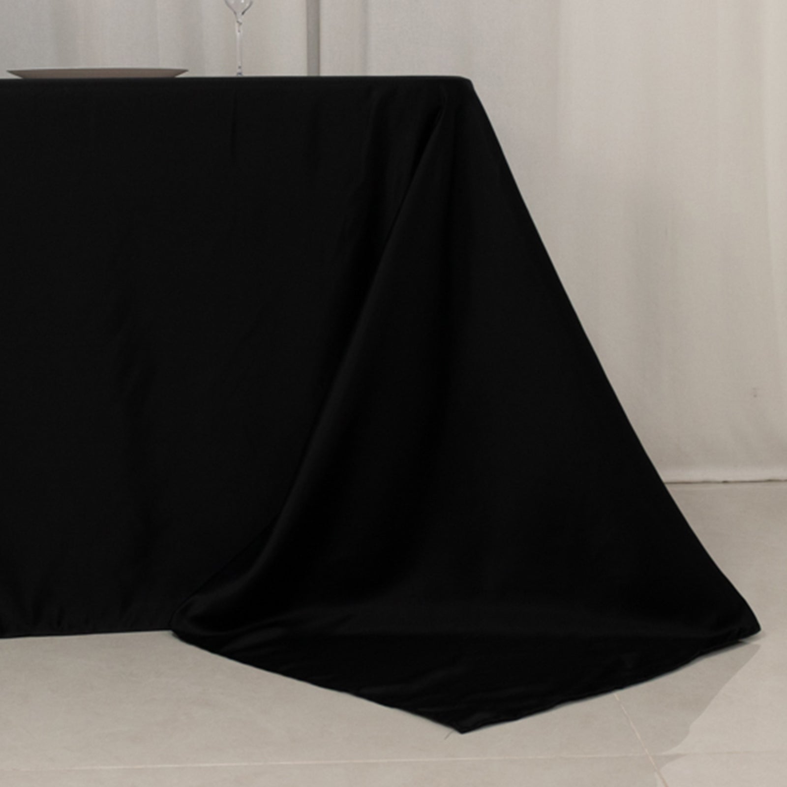 Black seamless satin tablecloth for an 8-foot table with floor-length drop.