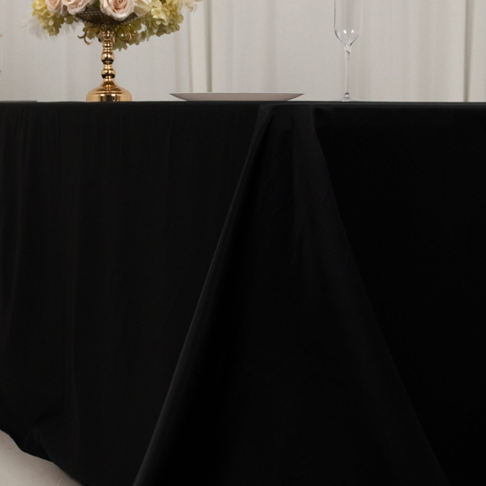 Black seamless lamour satin tablecloth for 8 foot table with floor-length drop.