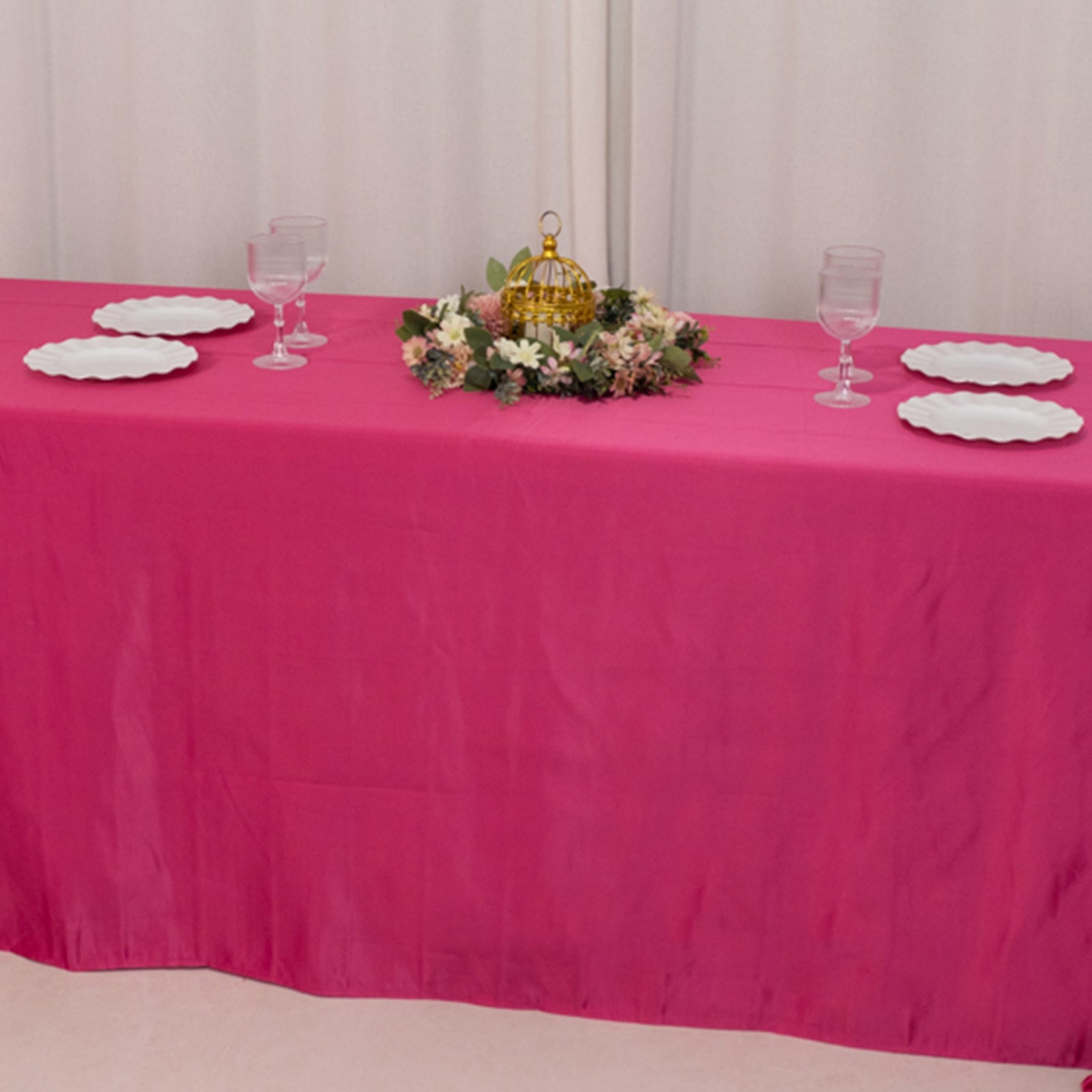 Fuchsia satin tablecloth draped over an 8-foot table with floral centerpiece.