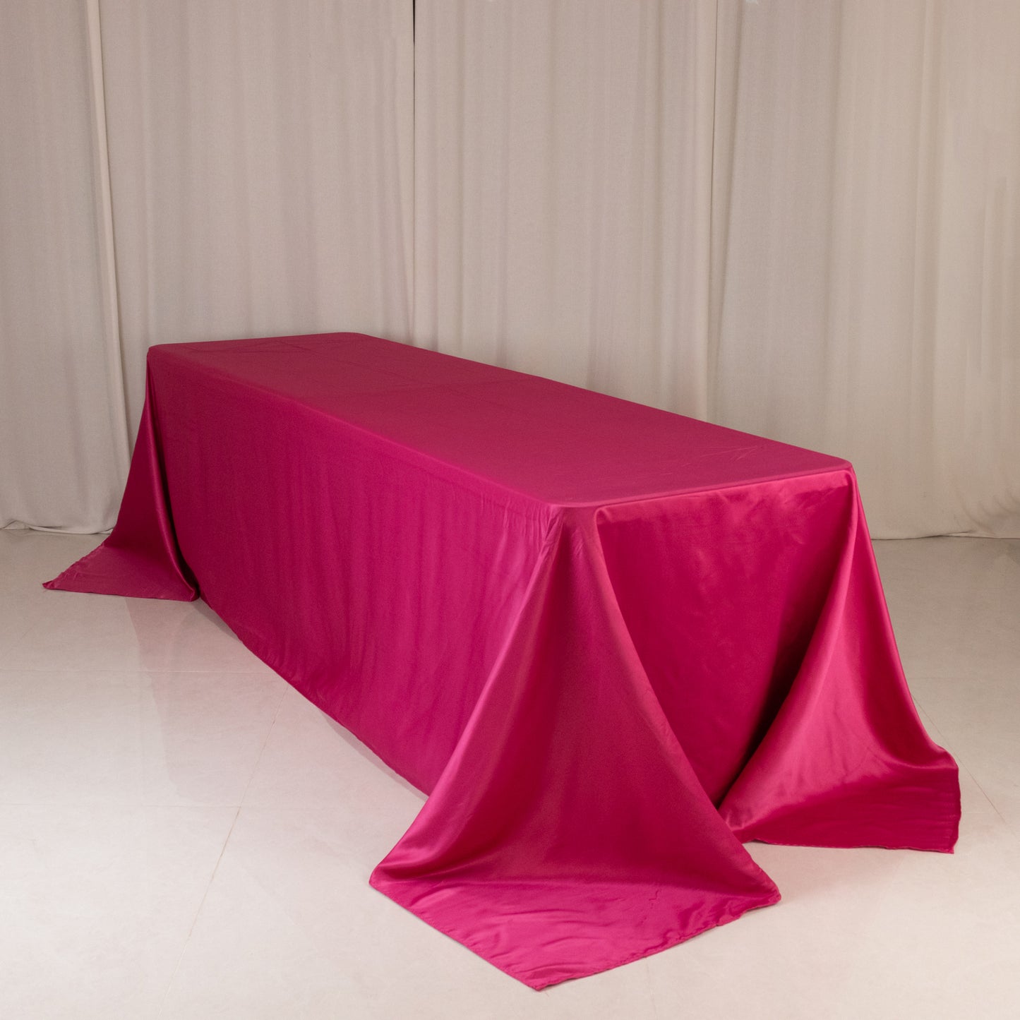 Fuchsia satin tablecloth for 8-foot table with floor-length drop.