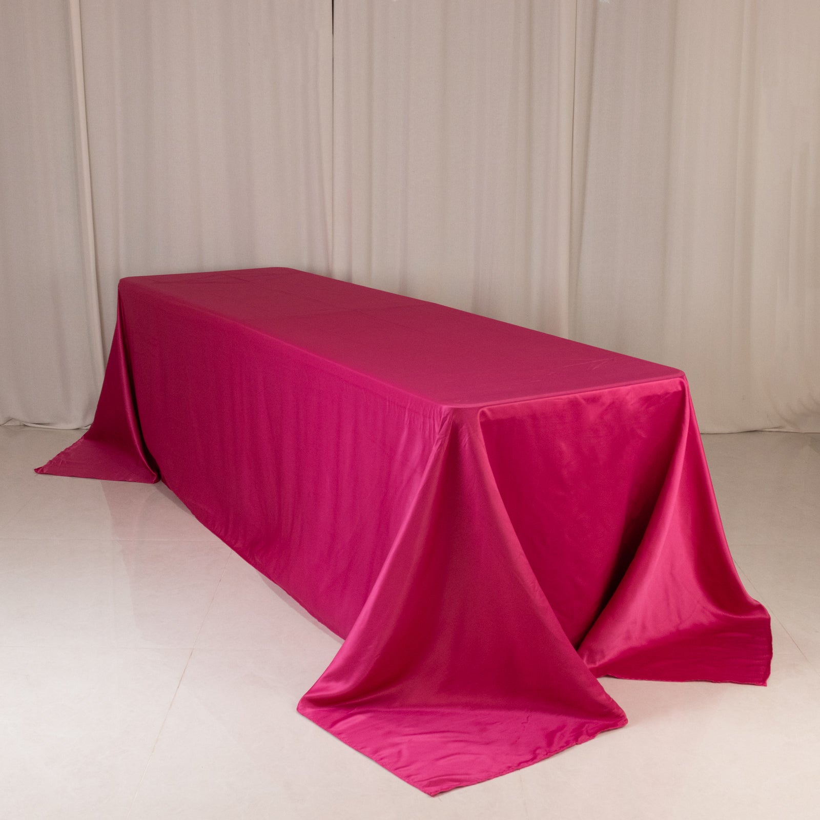 Fuchsia satin tablecloth for 8-foot table with floor-length drop.
