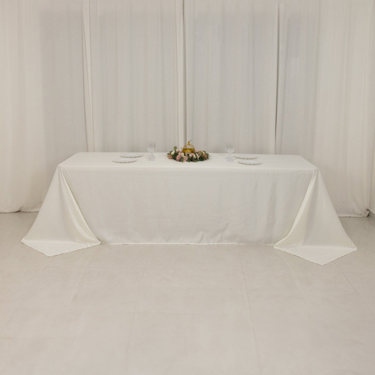 Ivory seamless satin tablecloth for 8-foot table with floor-length drop.