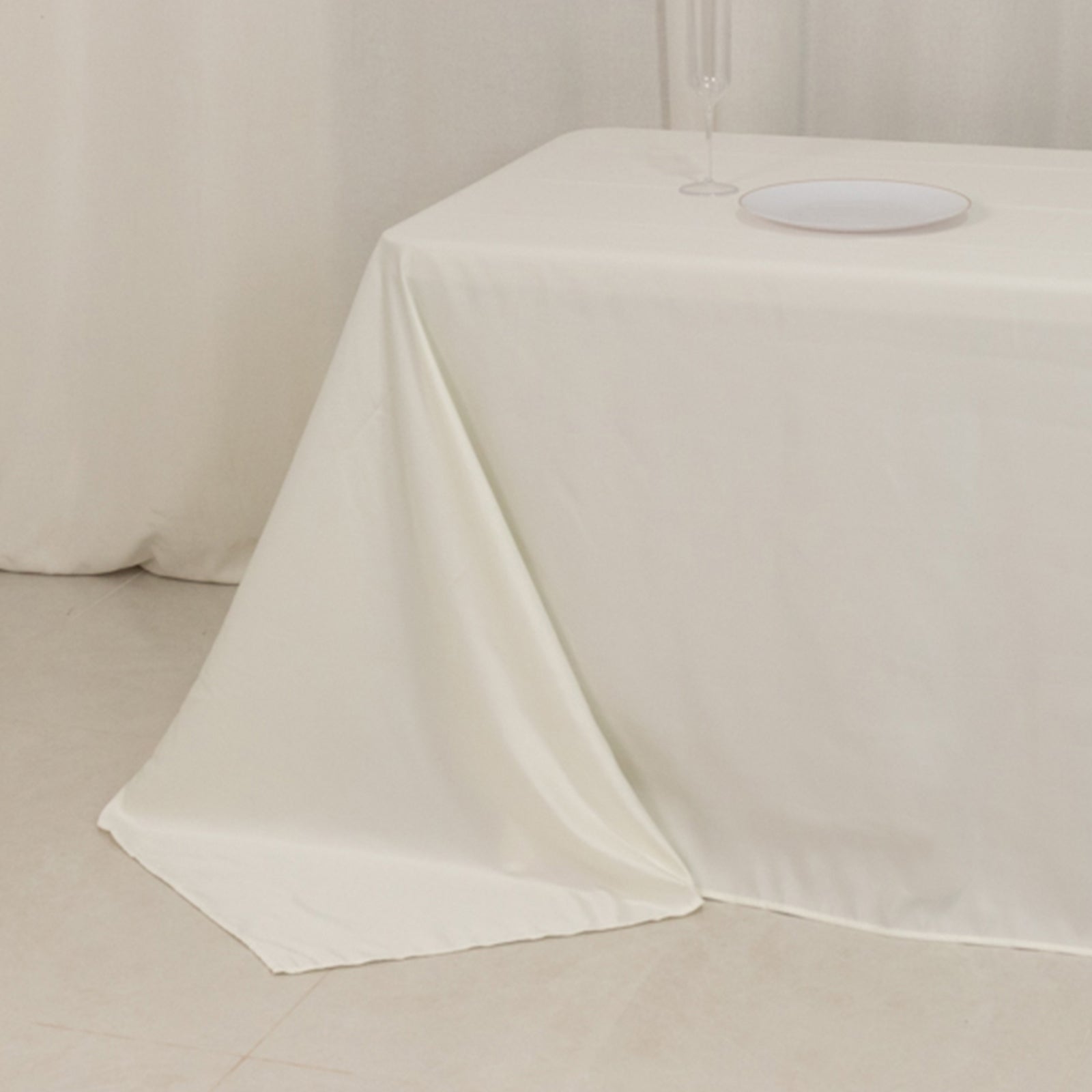 Ivory seamless satin tablecloth for 8-foot table with floor-length drop.