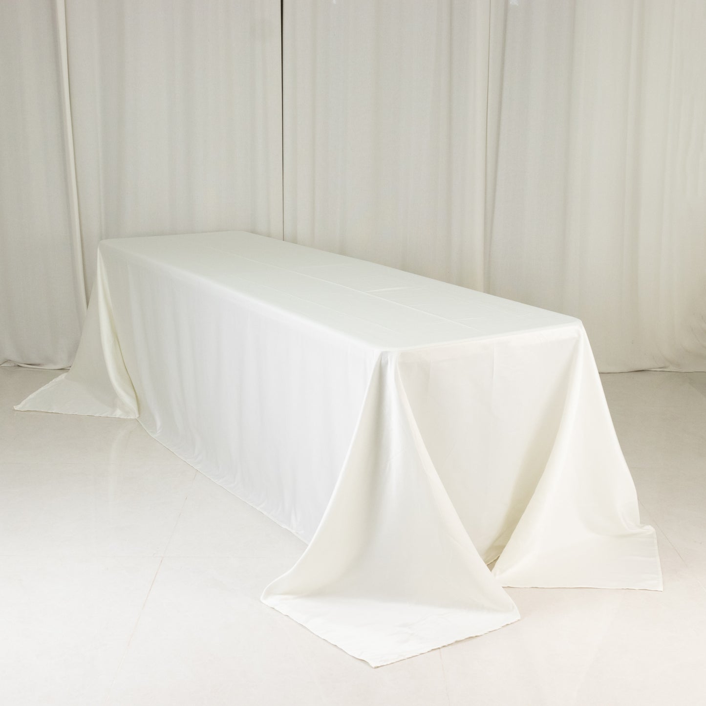 Ivory seamless satin tablecloth for 8-foot table with floor-length drop.