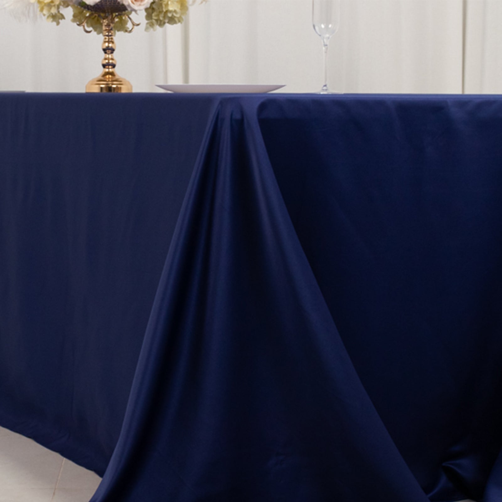 Navy blue seamless satin tablecloth for 8-foot table with floor-length drop.