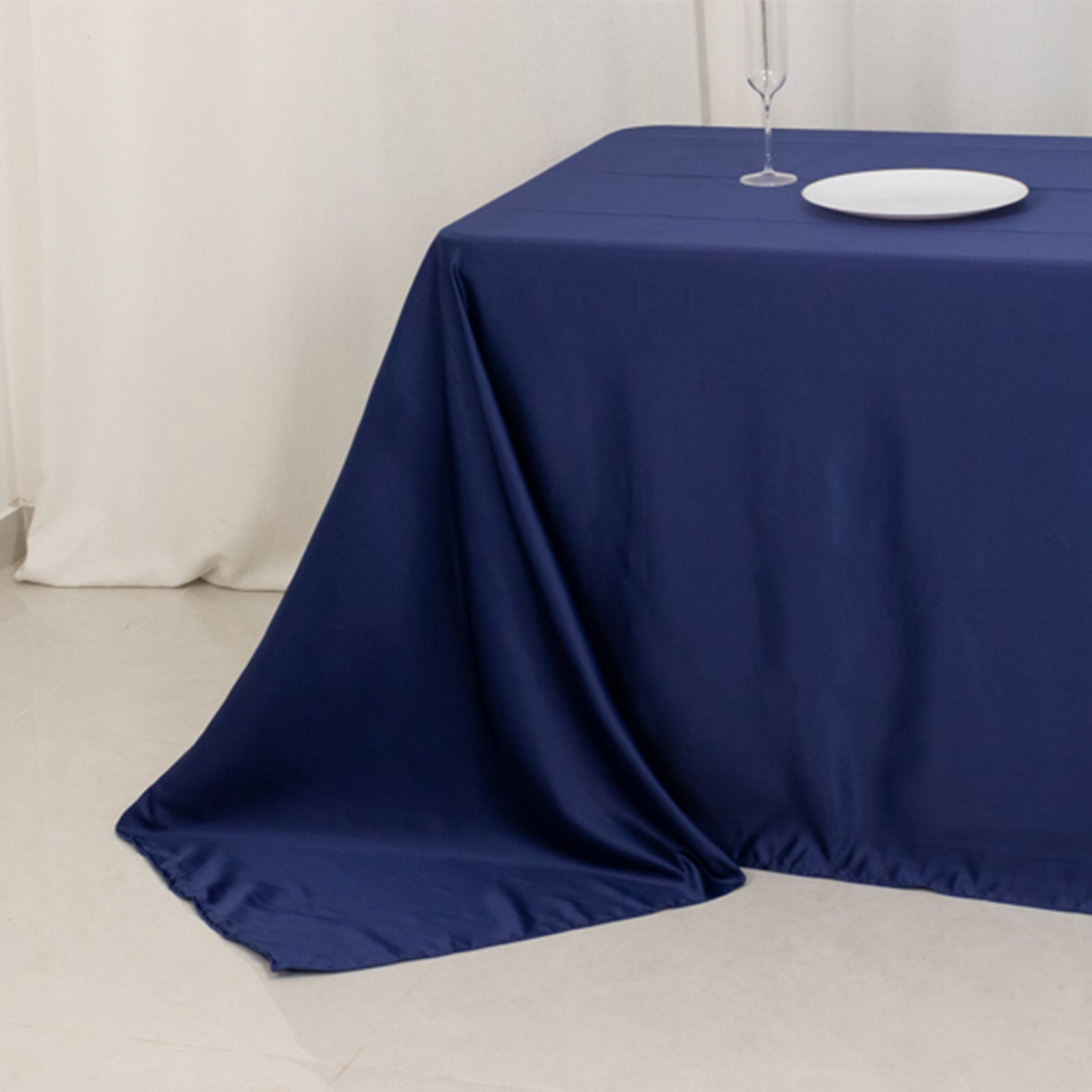 Navy blue seamless satin tablecloth for 8-foot table with floor-length drop.