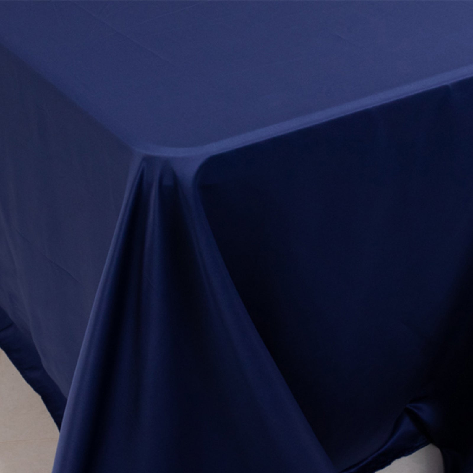 Navy blue seamless satin tablecloth for 8-foot table with floor-length drop.