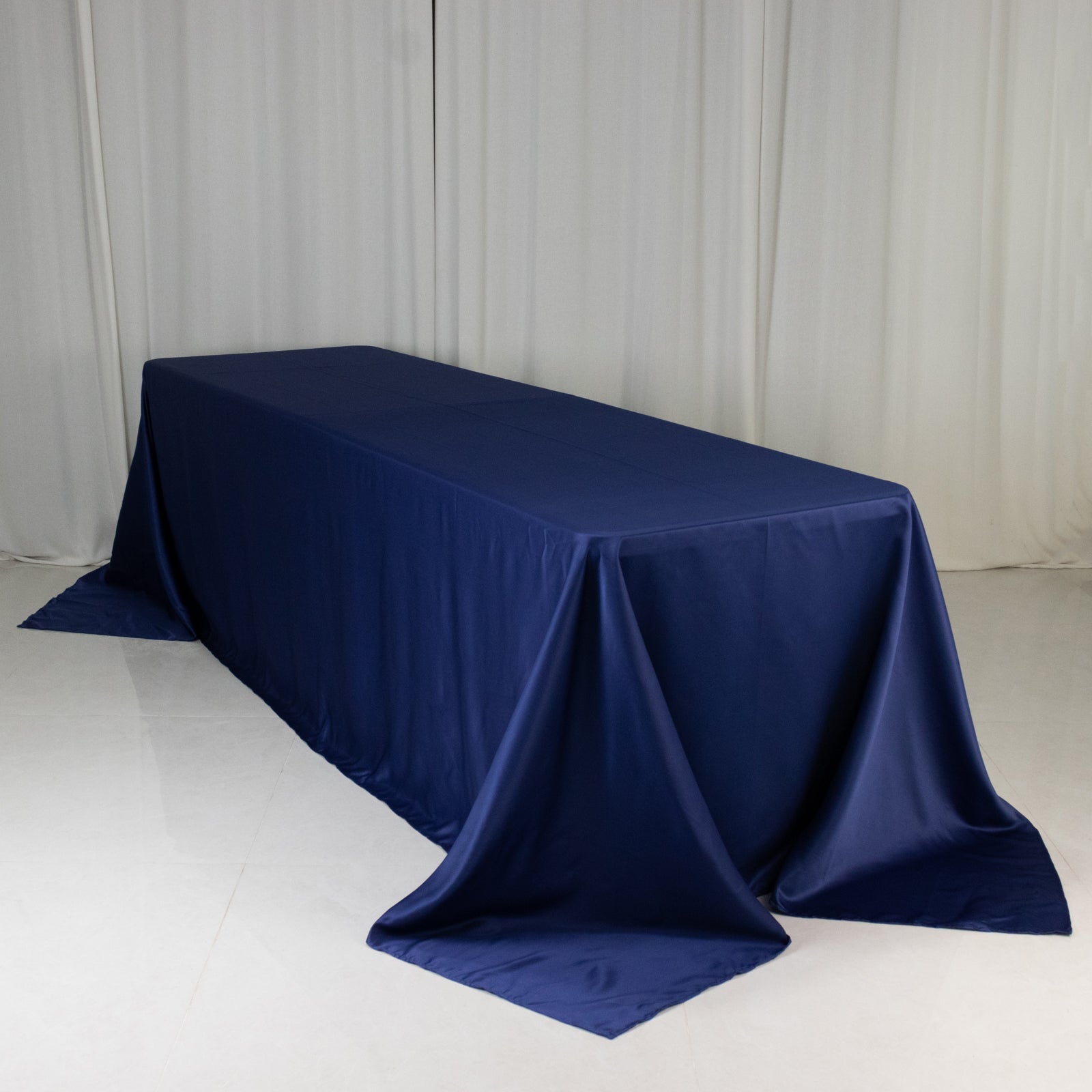 Navy blue seamless satin tablecloth for 8-foot table with floor-length drop.