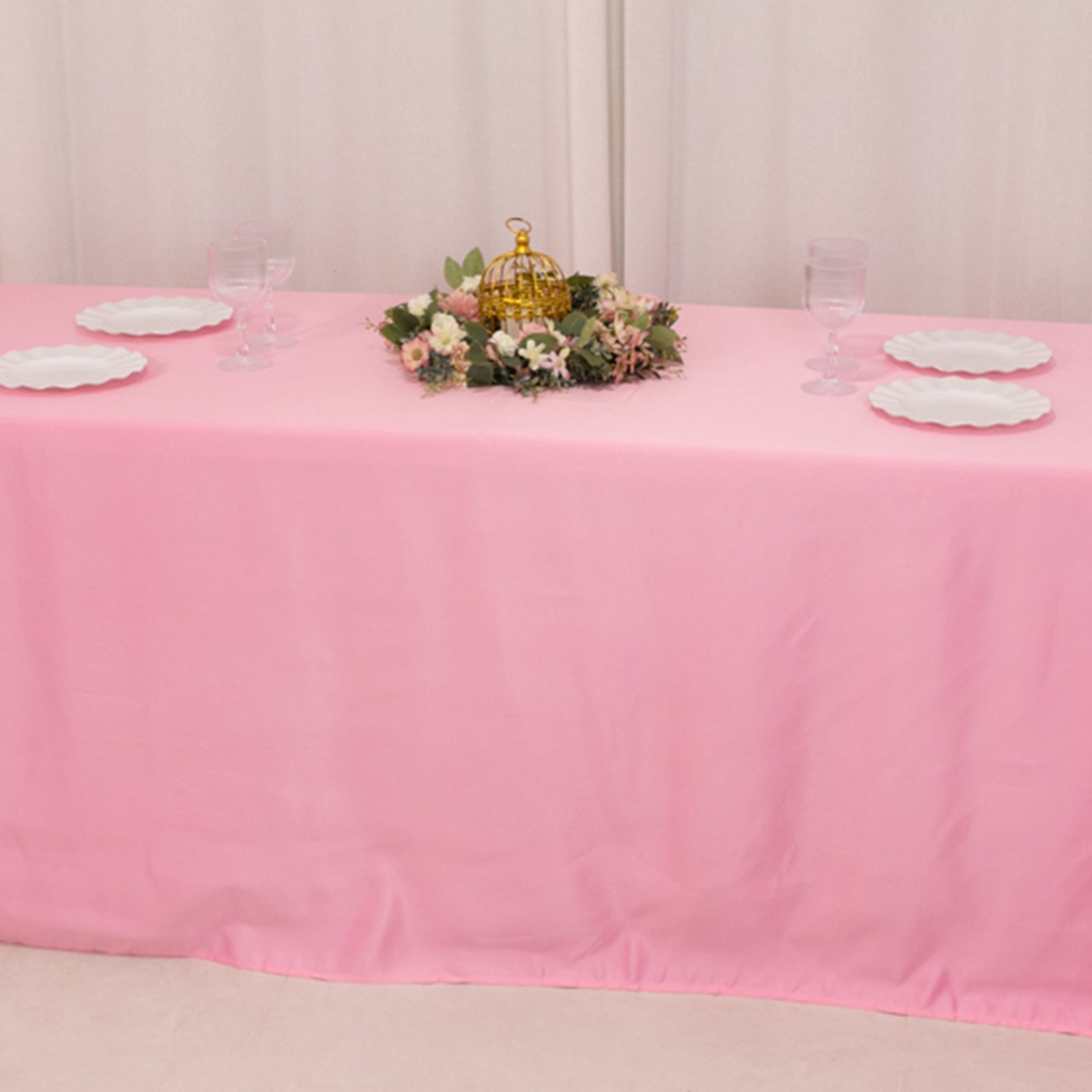 Pink seamless satin tablecloth draped over an 8-foot table with floral centerpiece.