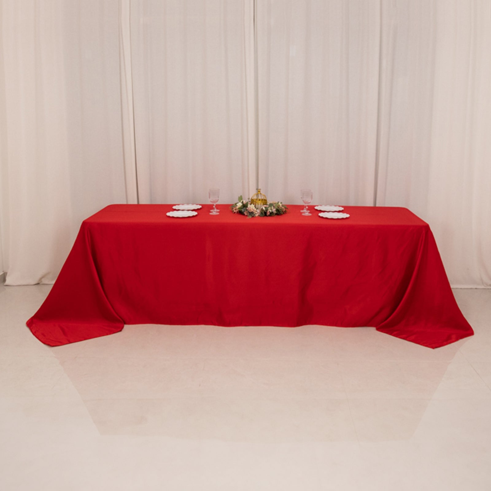 Red seamless satin tablecloth for 8-foot table with floor-length drop.