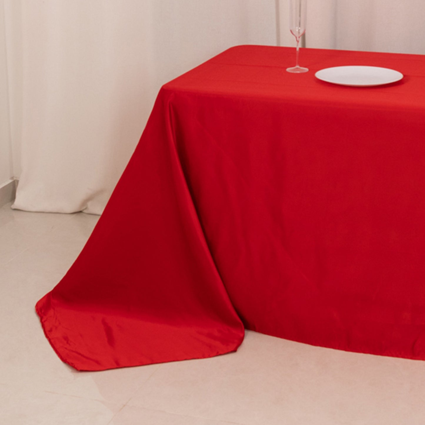 Red seamless satin tablecloth for 8-foot table with floor-length drop.