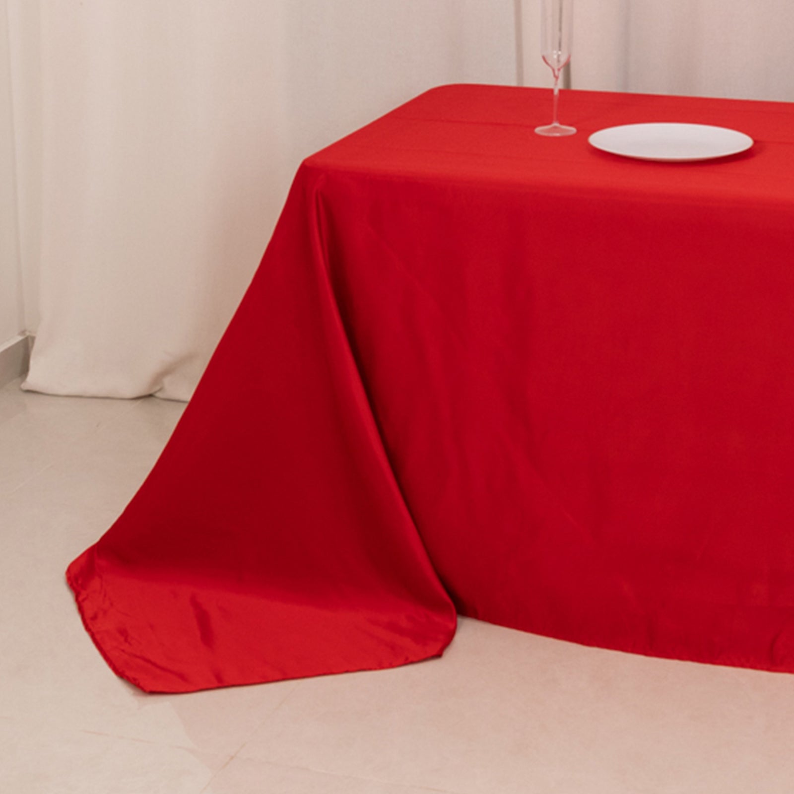 Red seamless satin tablecloth for 8-foot table with floor-length drop.