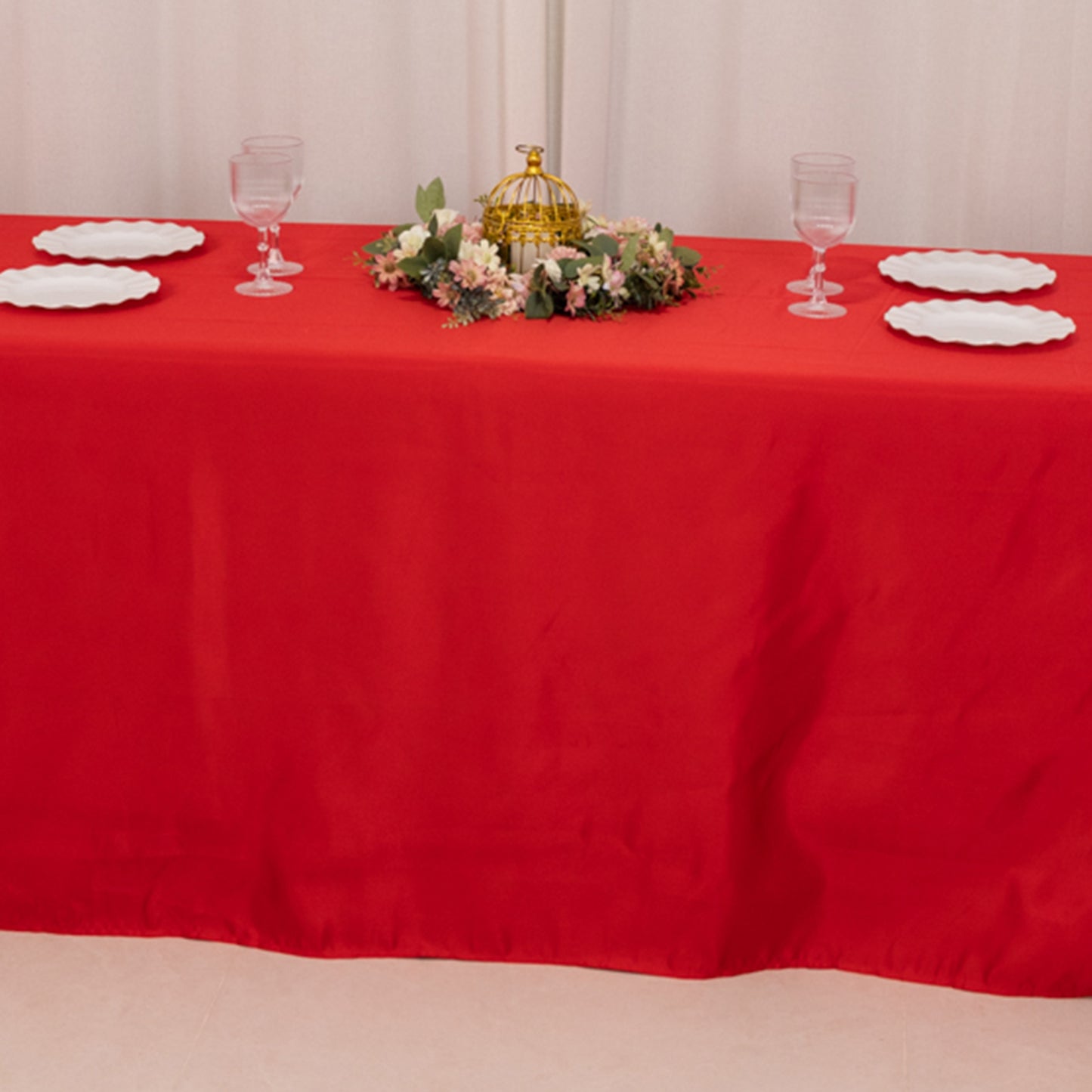 Red satin tablecloth on an 8-foot table with decorative centerpiece.
