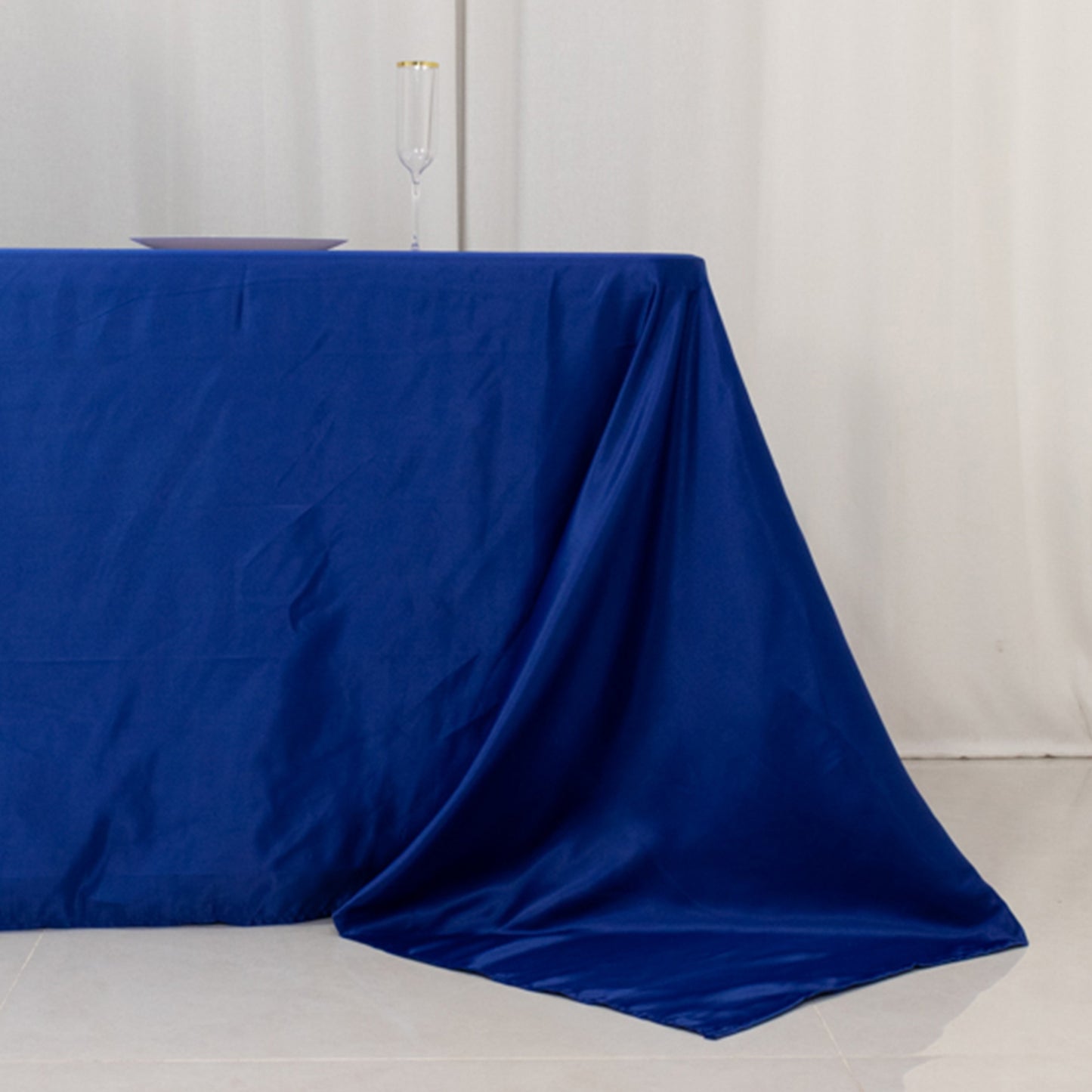 Royal blue satin tablecloth for 8-foot table with floor-length drop.