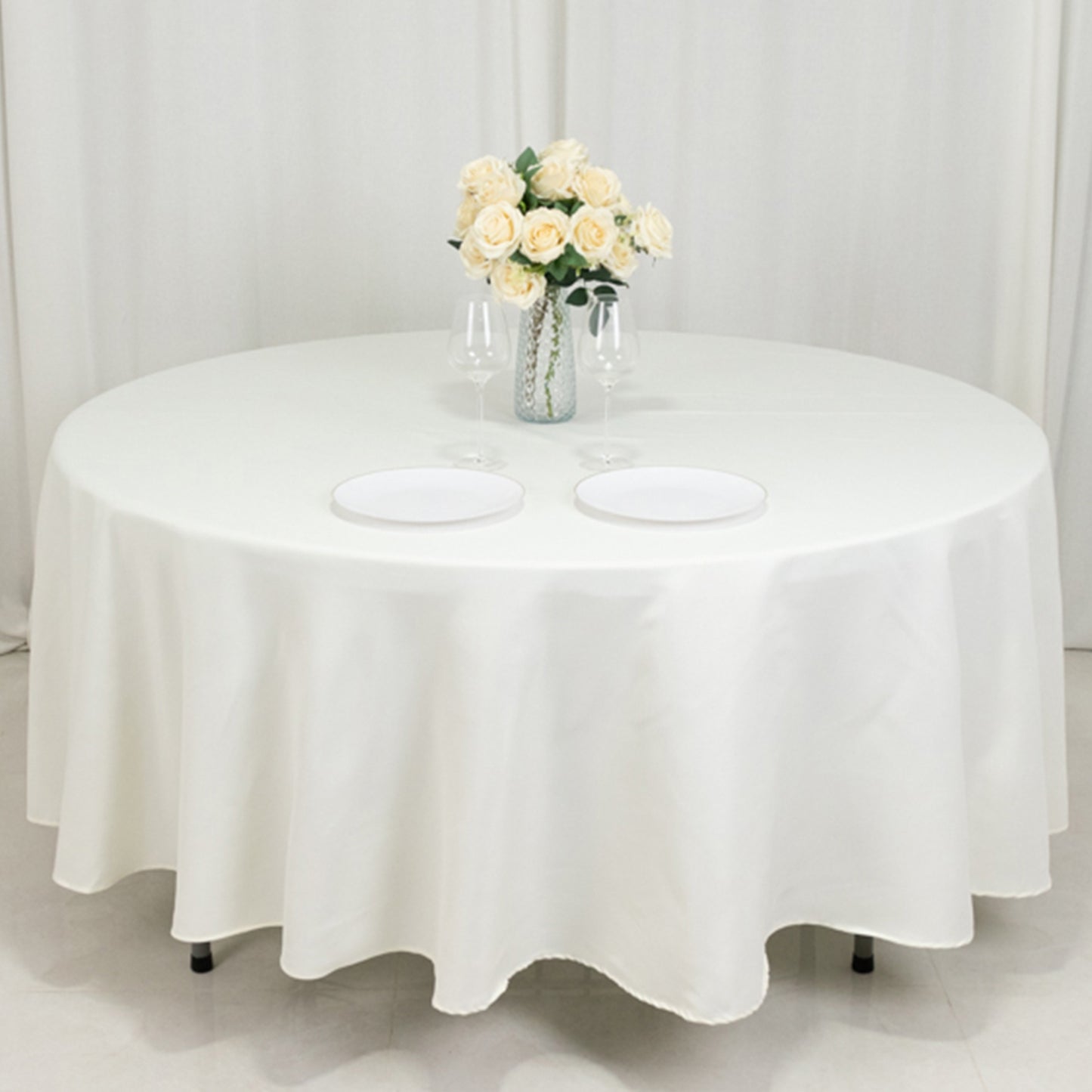 Ivory fire retardant round tablecloth on a round table with floral centerpiece.