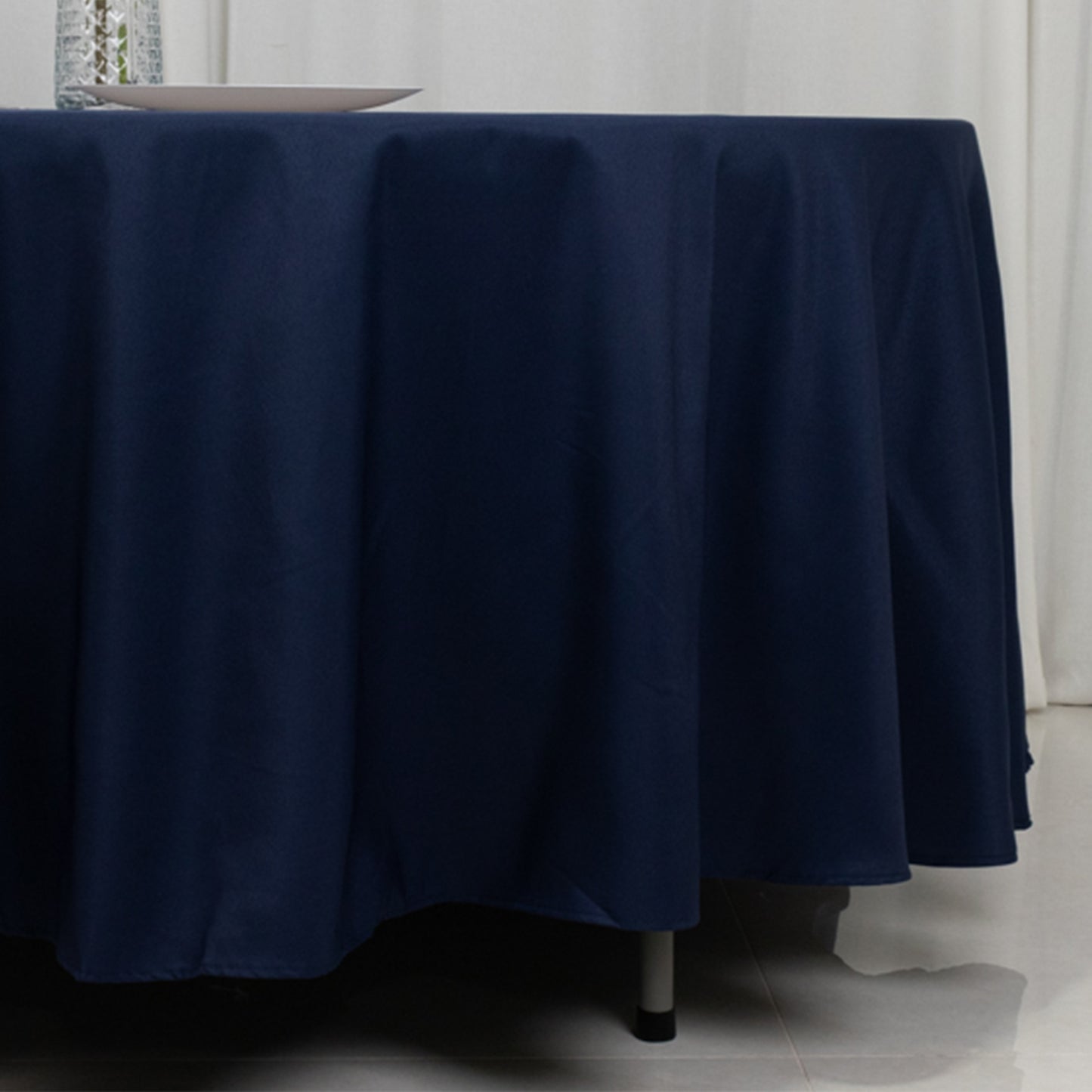 Navy blue round tablecloth draping over a table.