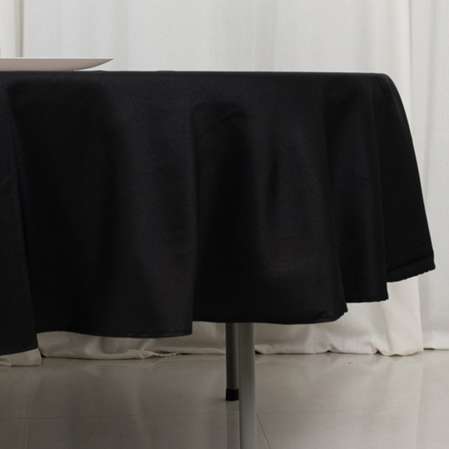 Black fire retardant round table cover on a table.
